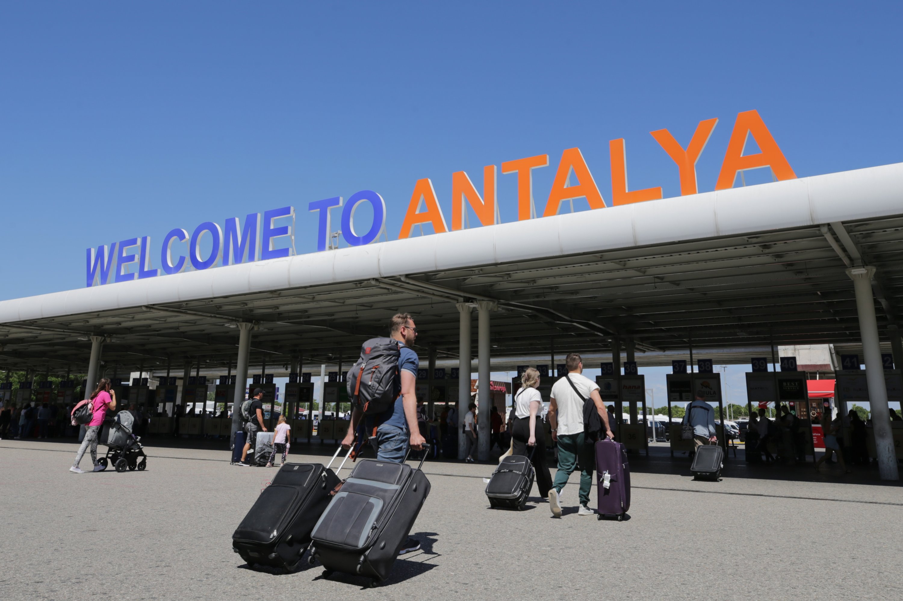 281103 Tourists exit the airport as they arrive in the Mediterranean tourism hot spot Antalya, southern Türkiye, June 6, 2023. (AA Photo)