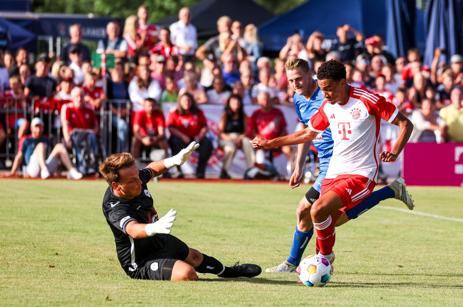 Bayern Munich's Jamal Musiala (R) challenges Rottach-Egern's Mario Weiss during the preseason friendly match, Rottach-Egern, Germany, July 18, 2023. (Getty Images Photo)