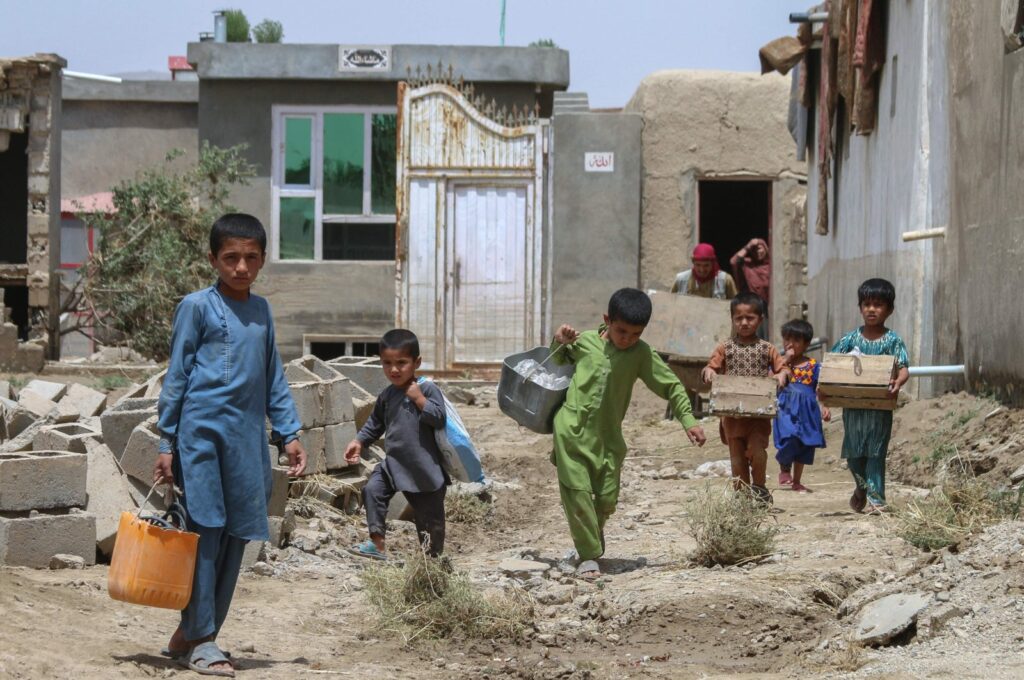 Afghan children carry their belongings following flash floods in the Khair Abad area in Ghazni province, Afghanistan, July 23, 2023. (AFP Photo)