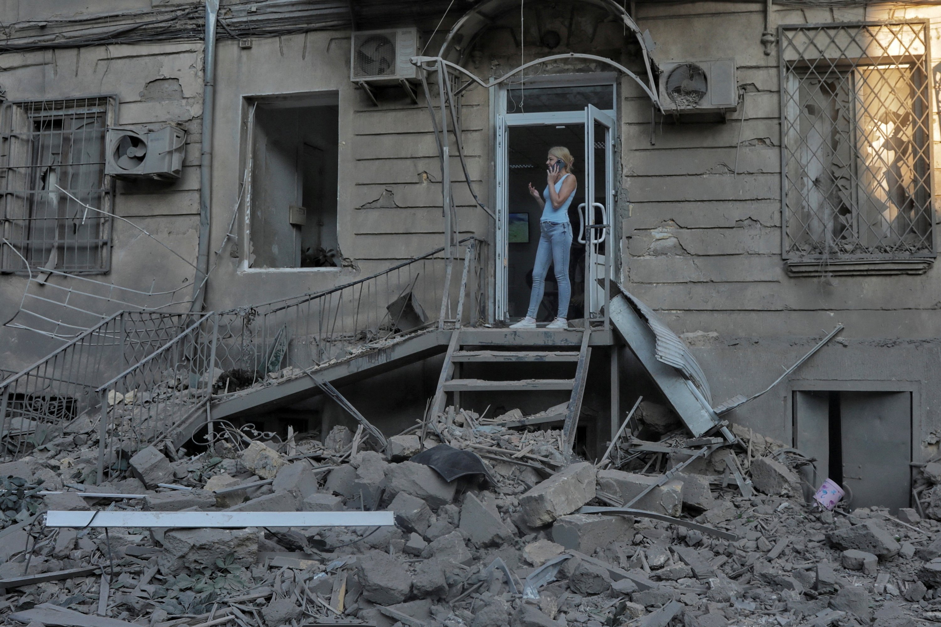 284058 A woman speaks on her mobile next to a building damaged during Russian missile strikes in Odessa, Ukraine, July 23, 2023. (Reuters Photo)
