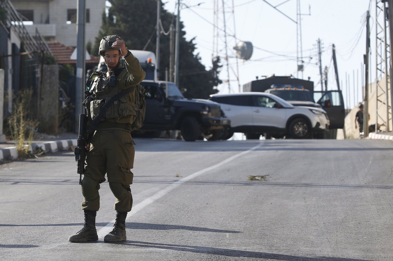 An Israeli soldier stands at the area where three Palestinians were shot dead near Nablus, occupied West Bank, Palestine, July 25, 2023. (EPA Photo)