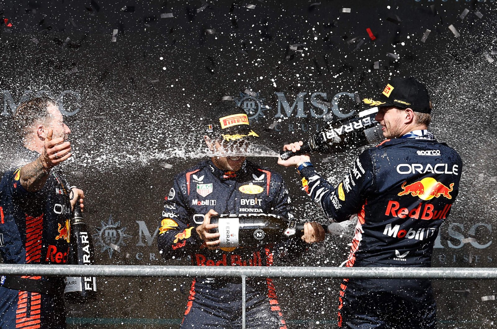 Winner Red Bull Racing's Dutch driver Max Verstappen (R) and second-placed Red Bull Racing's Mexican driver Sergio Perez (C) celebrate with a team member on the podium after the Formula One Belgian Grand Prix at the Spa-Francorchamps Circuit, Spa, Belgium, July 30, 2023. (AFP Photo)