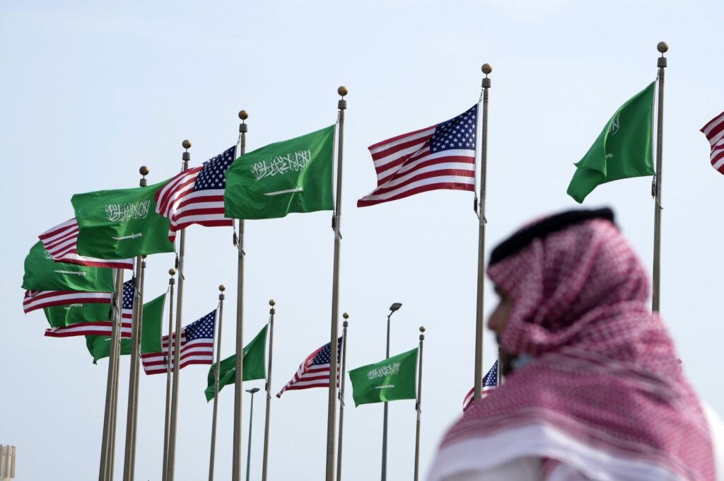 A man stands under American and Saudi Arabian flags prior to a visit by U. S. President Joe Biden, at a square in Jeddah, Saudi Arabia, Thursday, July 14, 2022. (AP File Photo)