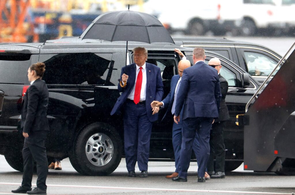 Former U.S. President Donald Trump holds an umbrella as he arrives at Reagan National Airport following an arraignment in a Washington, D.C. court in Arlington, Virginia, U.S., Aug. 3, 2023. (AFP Photo)