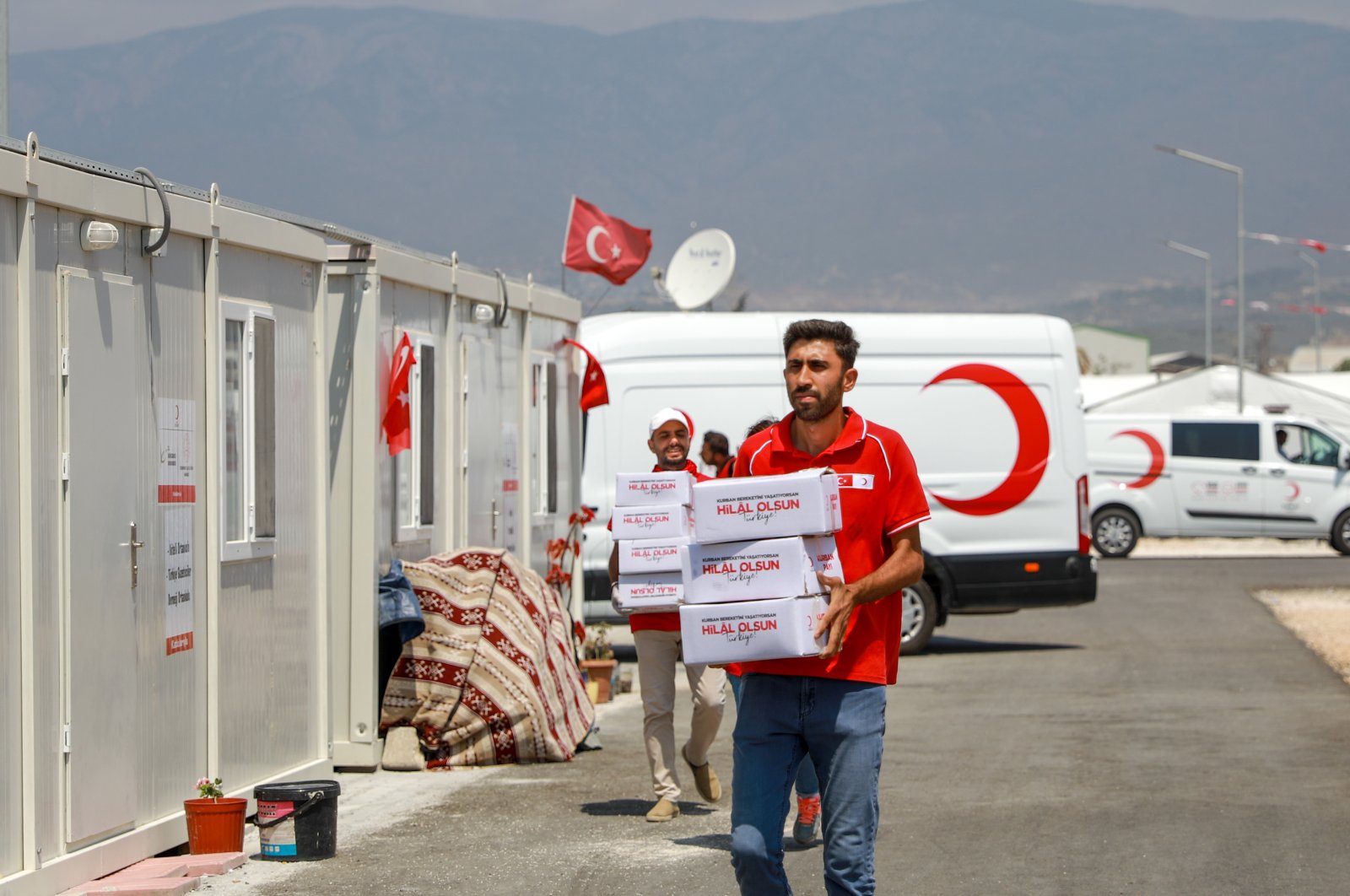 A volunteer of the Turkish Red Crescent (Kızılay) is photographed dispatching packages of Qurban meat in a container city in southeastern Türkiye, July 13, 2023. (AA Photo)