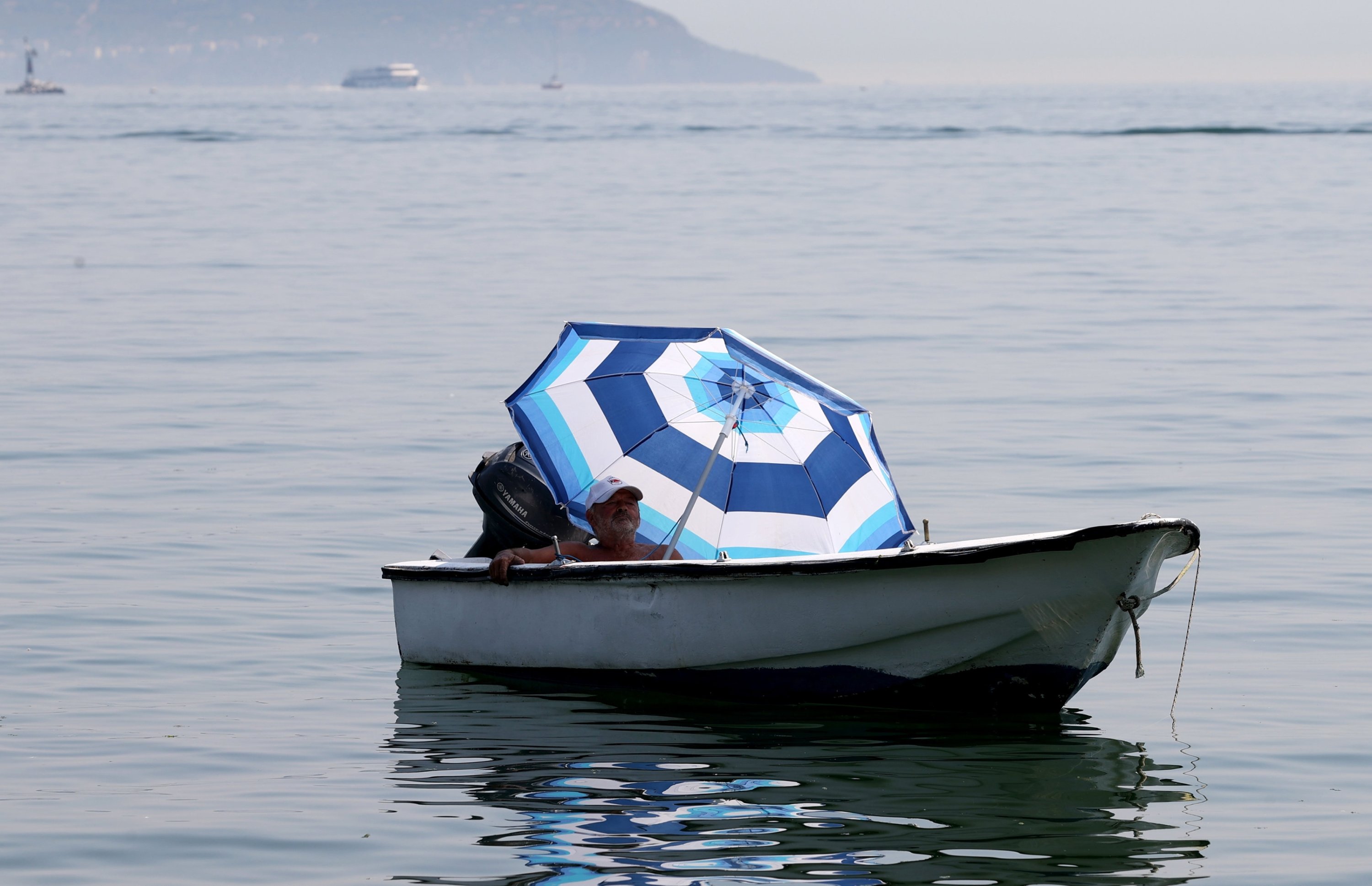 285939 A citizen under the shade of an umbrella in sea waters close to Istanbul's Kadıköy district, Istanbul, Türkiye, Aug. 3, 2023. (AA Photo)