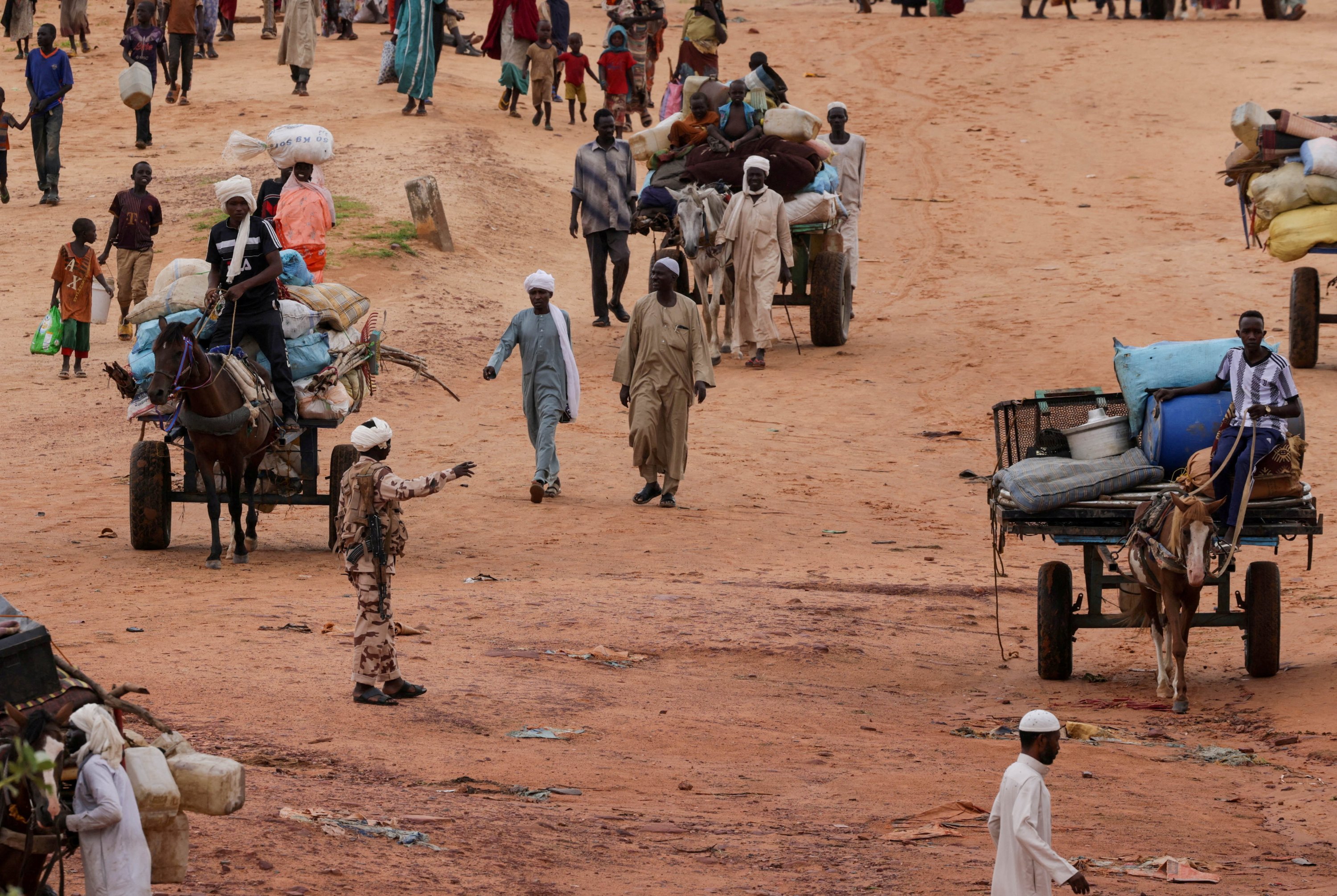 288345 A Chadian army officer reacts as Chadian cart owners transport the belongings of Sudanese people who fled the conflict in Sudan's Darfur region, while crossing the border between Sudan and Chad, Adre, Chad, Aug. 4, 2023. (Reuters Photo)