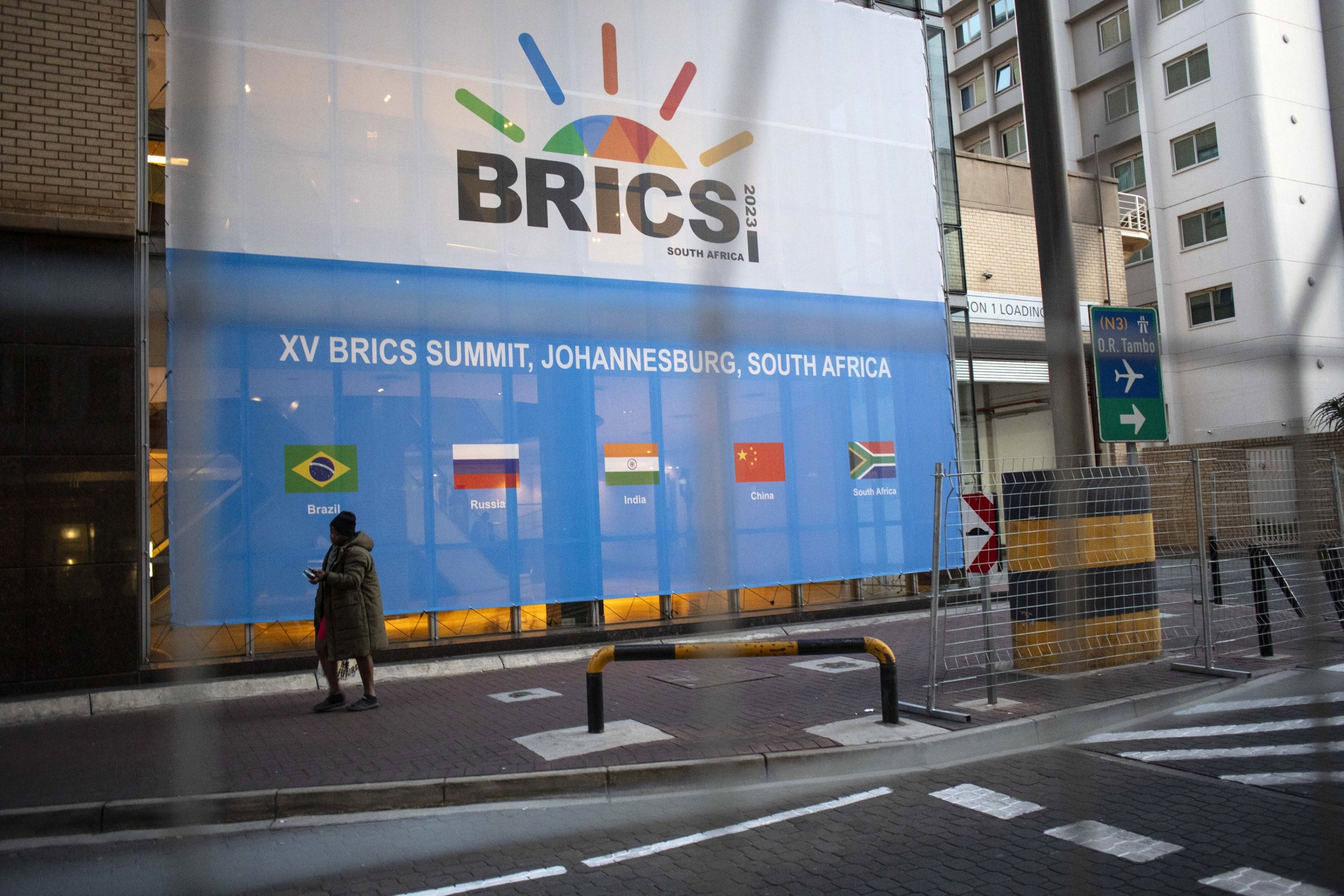 288518 A man walks past a banner as final preparations are underway for the 15th BRICS Summit at the Sandton Convention Centre, Johannesburg, South Africa, Aug. 21, 2023. (EPA Photo)