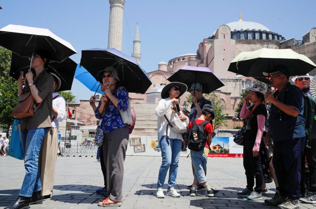 Tourists carry umbrellas to protect themselves from the sun as they visit the old city of Istanbul, Türkiye, July 20, 2023. (Reuters Photo)