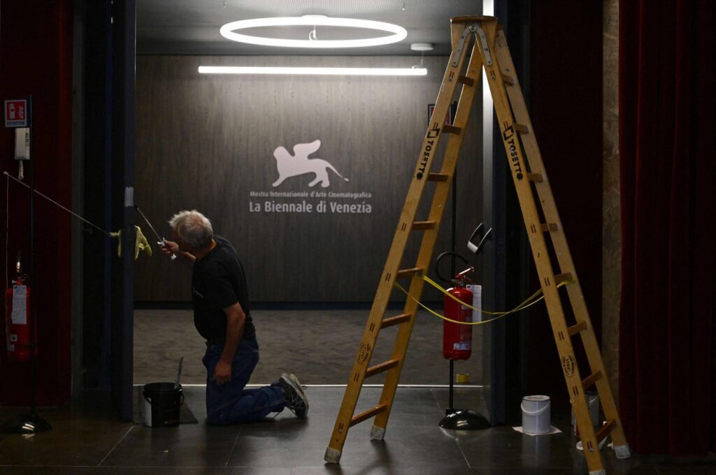A worker paints a door at the Palazzo del Casino where journalists gather on the eve of the 80th Venice Film Festival, Venice, Italy, Aug. 29, 2023. (AFP Photo)