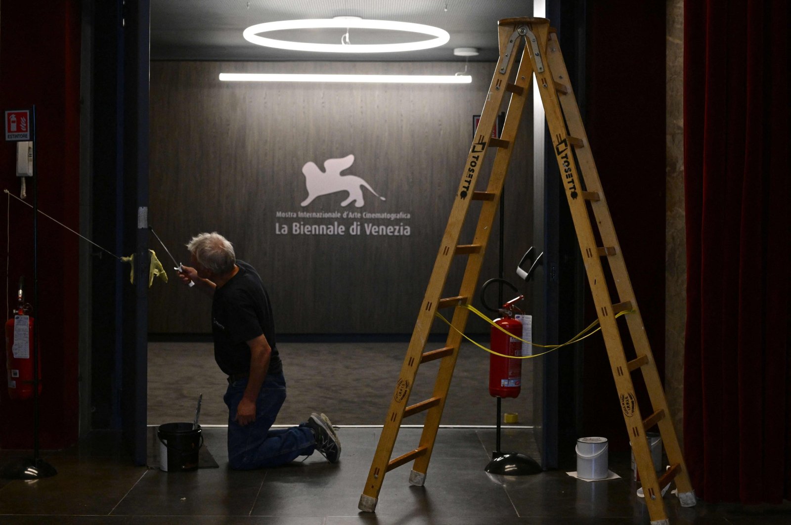 A worker paints a door at the Palazzo del Casino where journalists gather on the eve of the 80th Venice Film Festival, Venice, Italy, Aug. 29, 2023. (AFP Photo)