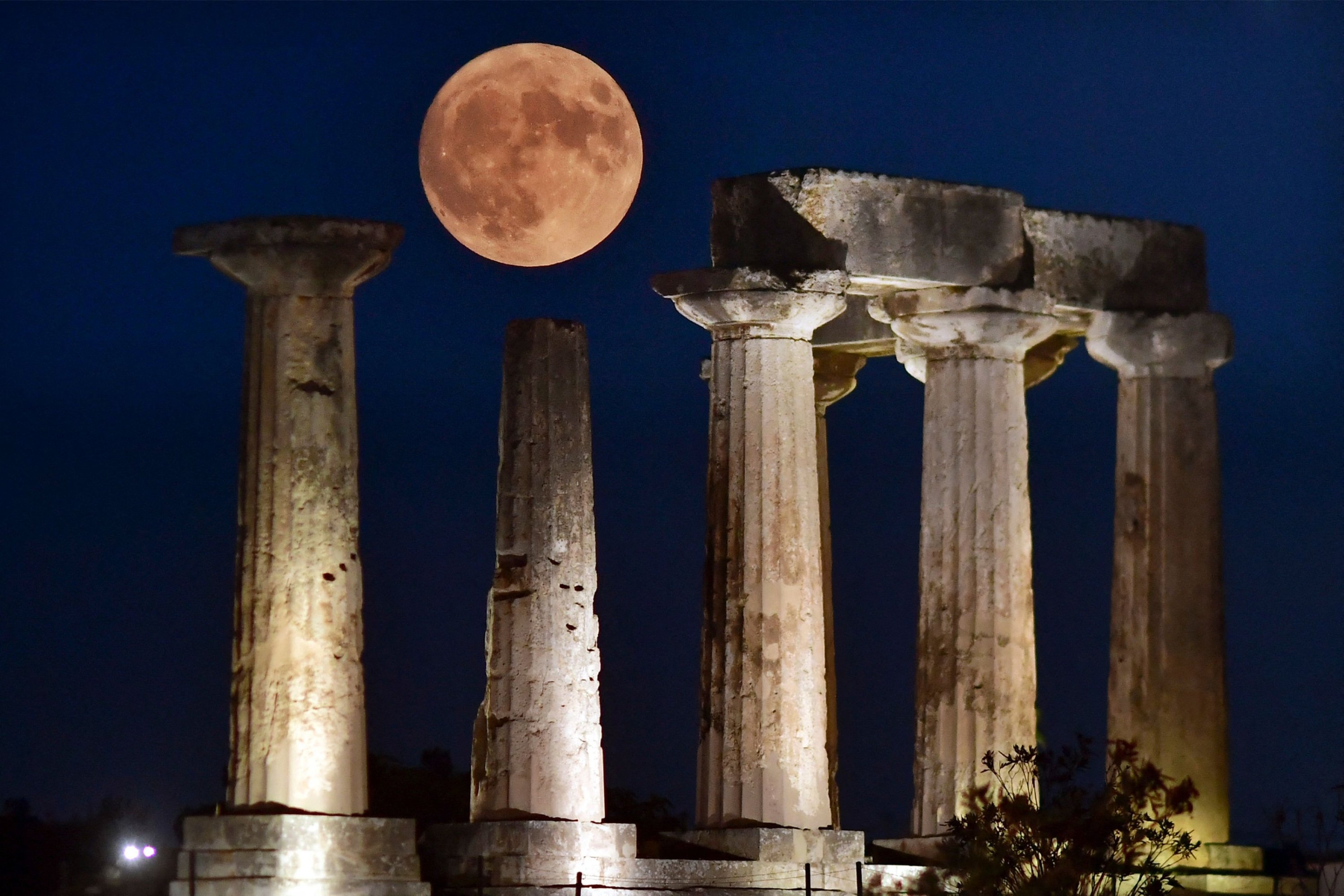 289957 The blue supermoon rises above the Apollo Temple in ancient Corinth, Greece, Aug. 30, 2023. (AFP Photo)