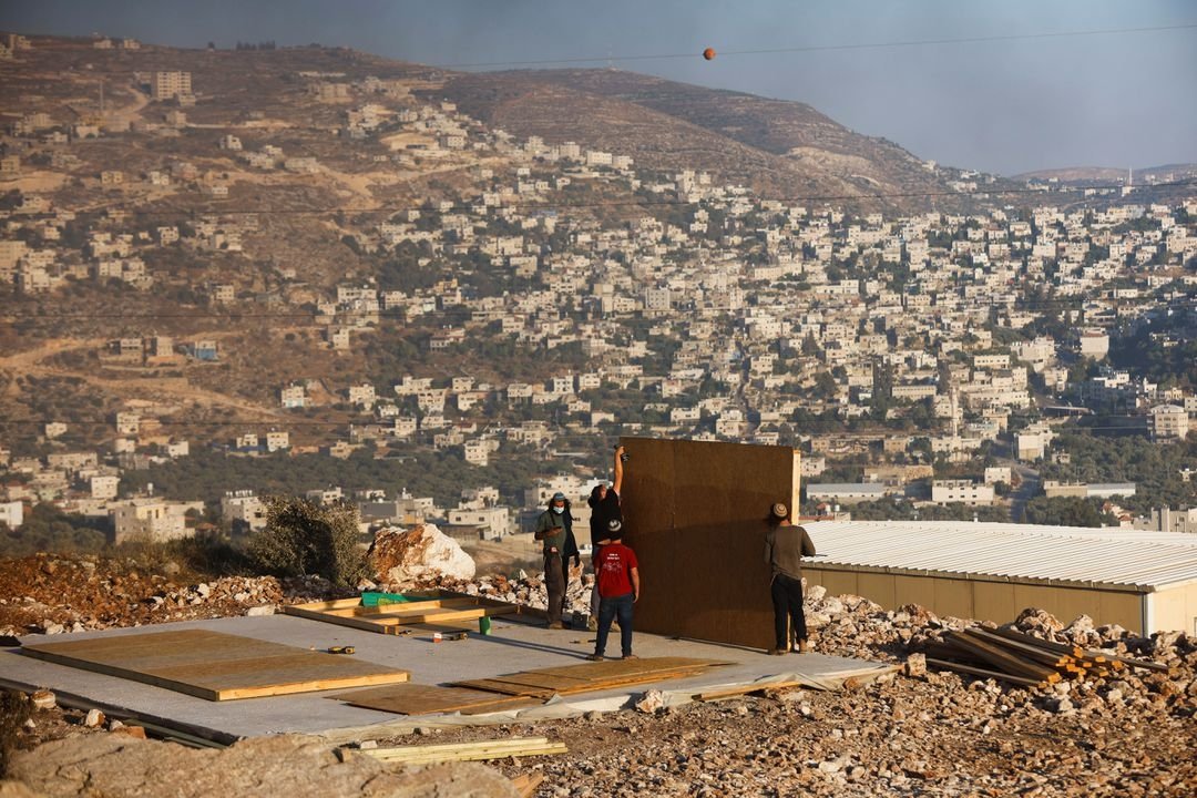 289997 Jewish settlers youths construct a structure in Givat Eviatar, a new Israeli settler outpost, near the Palestinian village of Beita in the Israeli-occupied West Bank, June 23, 2021. (Reuters Photo)