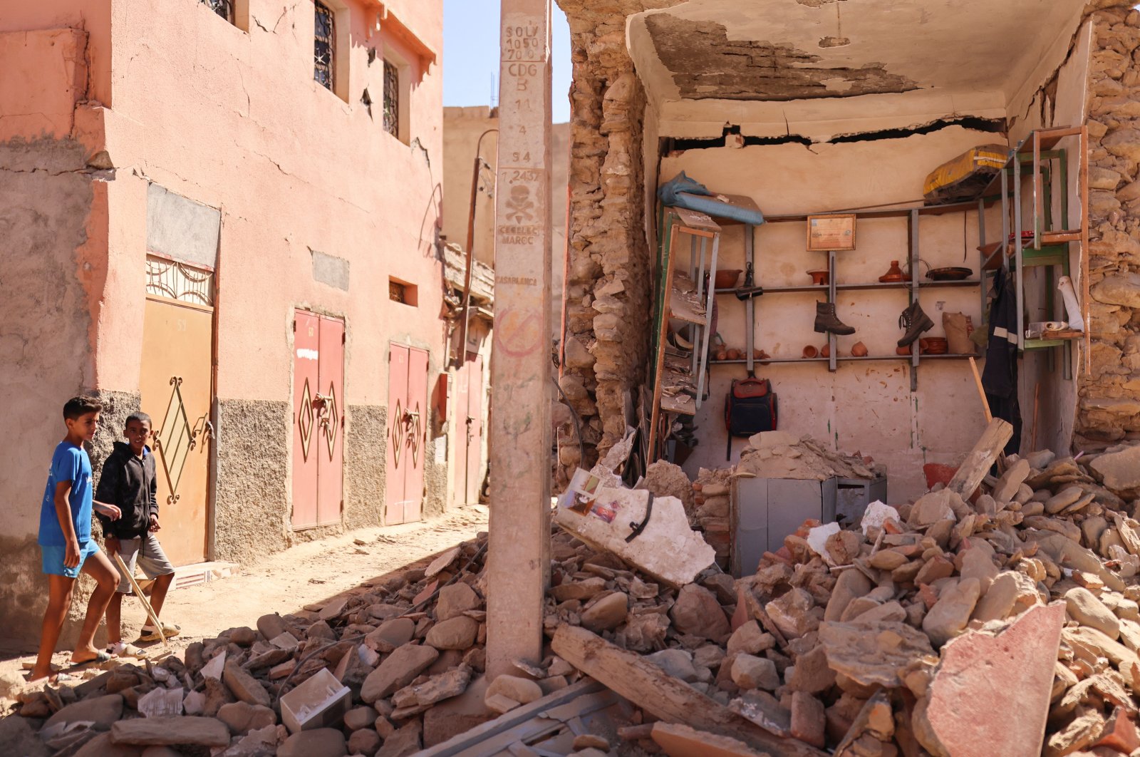 Children walk near a earthquake-damaged building, in Amizmiz, Morocco, Sept. 10, 2023. (Reuters Photo)