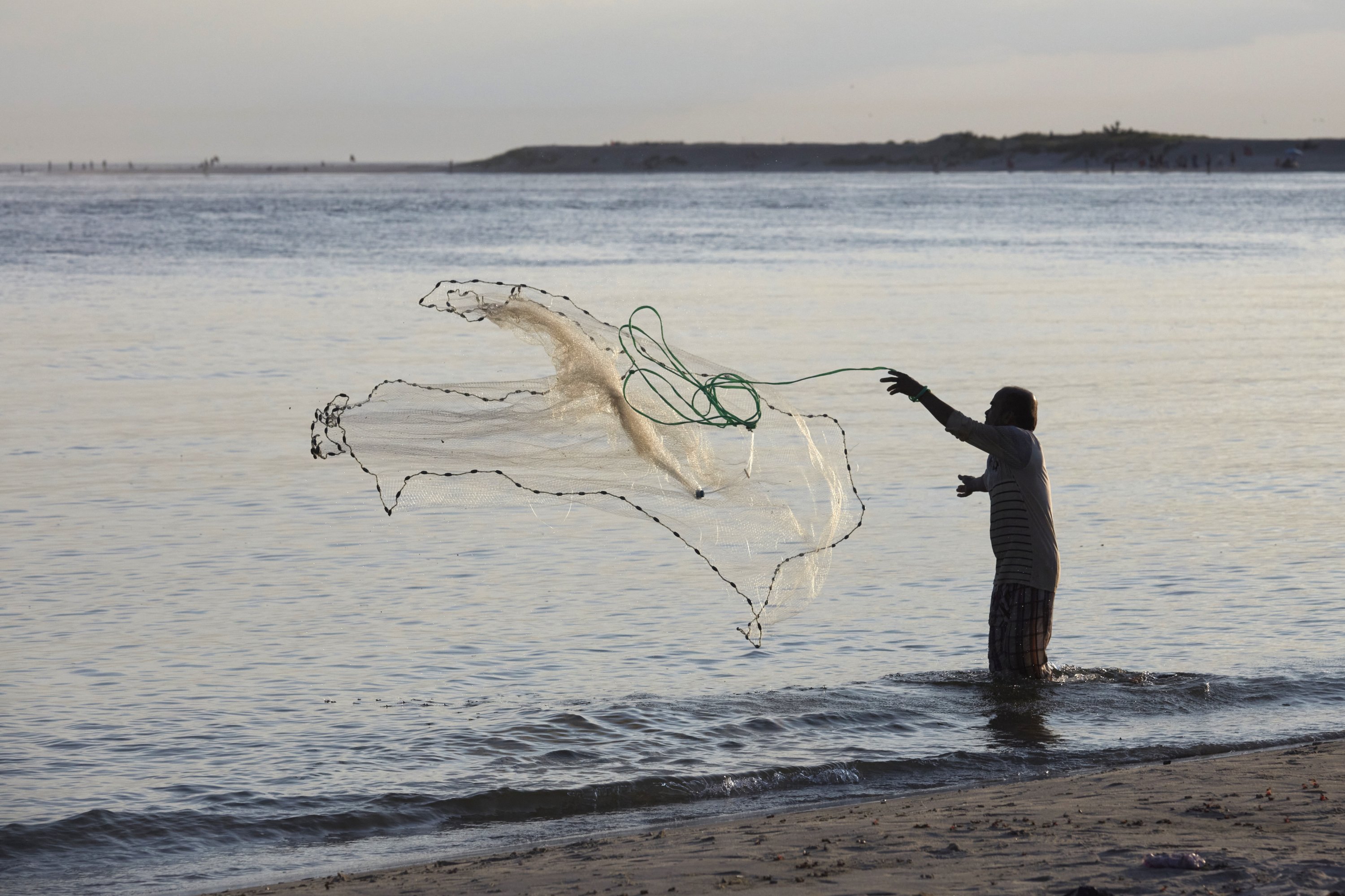 294661 A man fishes at the site where scuba divers conduct an underwater cleanup in the Queens borough of New York, U.S., Aug. 27, 2023. (AP Photo)