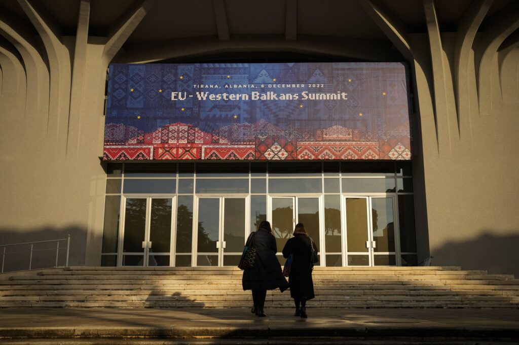 People walk outside the venue of the EU Western Balkans Summit, in Tirana, Albania, Dec. 5, 2022. (AP Photo)