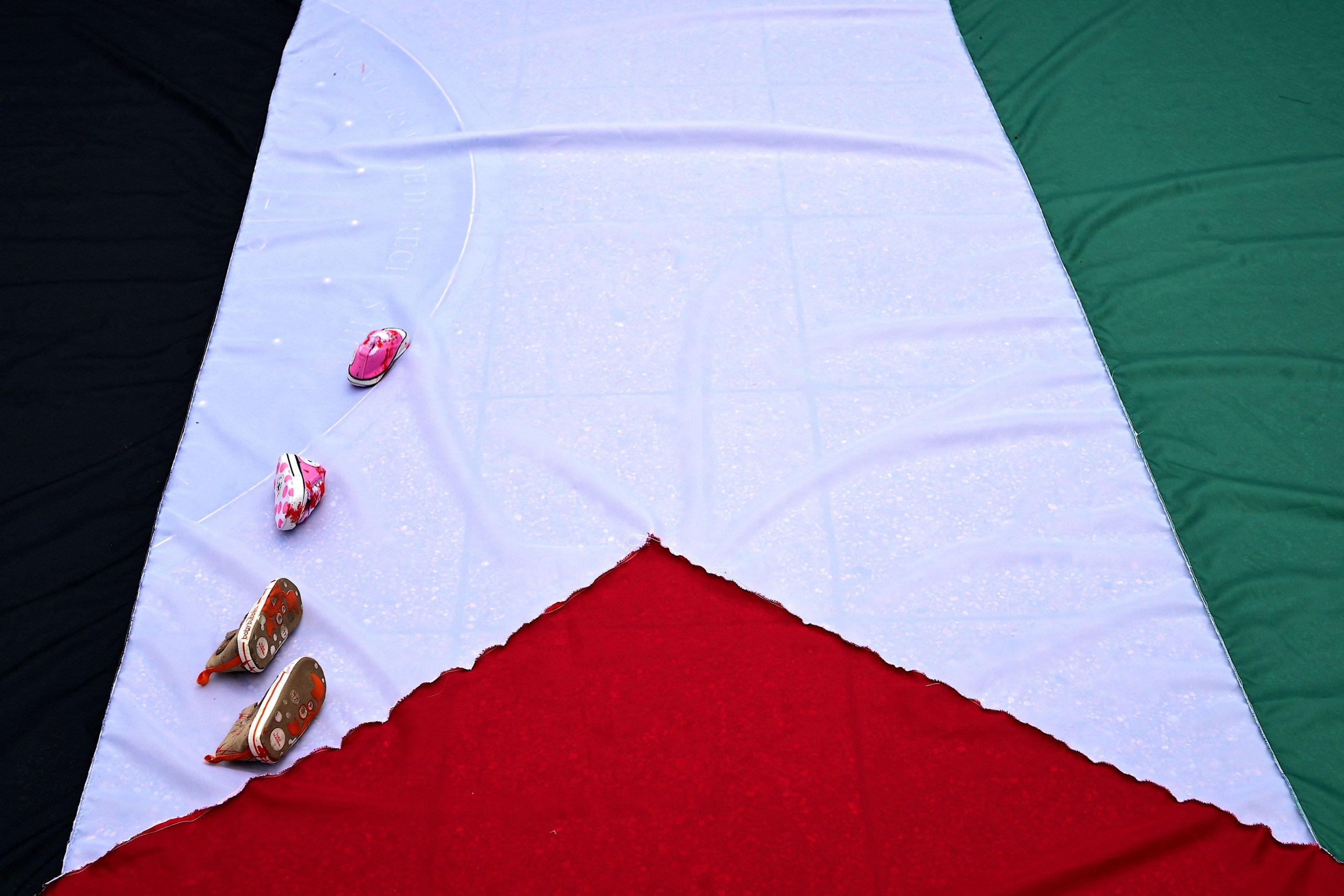301871 View of children shoes placed on a Palestinian flag during a demonstration asking for the ceasefire in Gaza, in front of the La Moneda presidential palace in Santiago, Chile, Nov. 18, 2023. (AFP Photo)