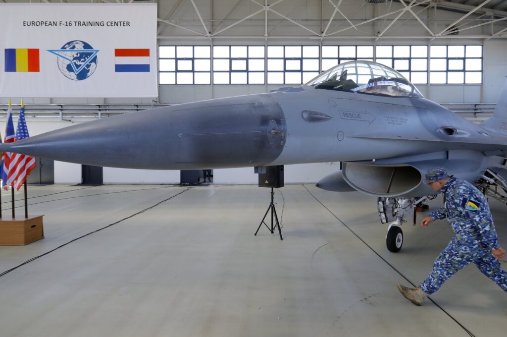 A Romanian Air Force military soldier passes an F15 Falcon jet airplane before the opening ceremony for the European F-16 Training Center, held at the 86th Air Base, Borcea, Romania, Nov. 13, 2023. (EPA Photo)