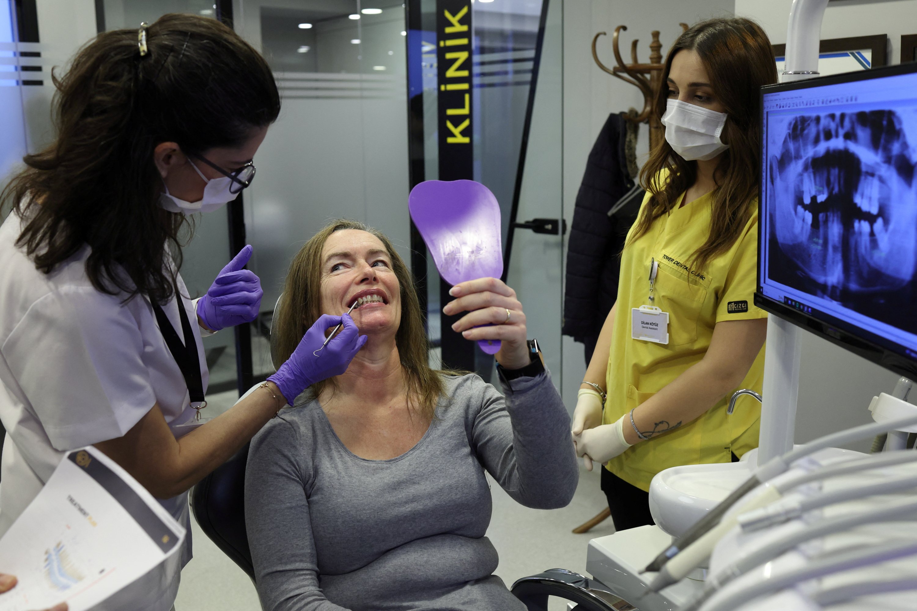 304914 Turkish dentist Gamze Etemoğlu treats her patient Marion Parks, a 55-year-old British woman from a village near Ipswich, Suffolk, during a dental implant operation in Istanbul, Türkiye, Dec. 4, 2023. (Reuters Photo)