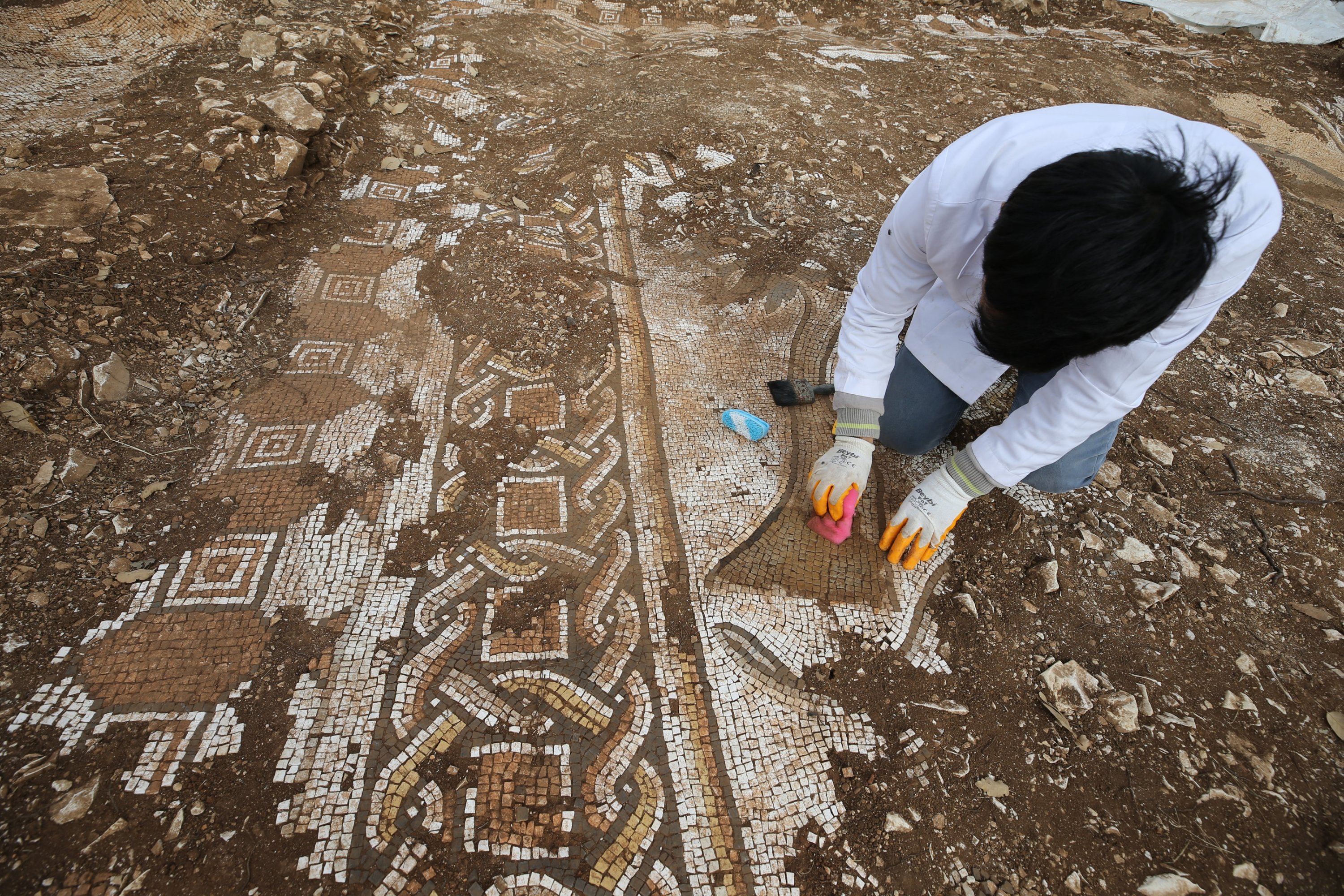 304991 An archaeologist brushes off the Roman mosaics found in the Kızıltepe district, Mardin, Türkiye, Dec. 11, 2023. (AA Photo)
