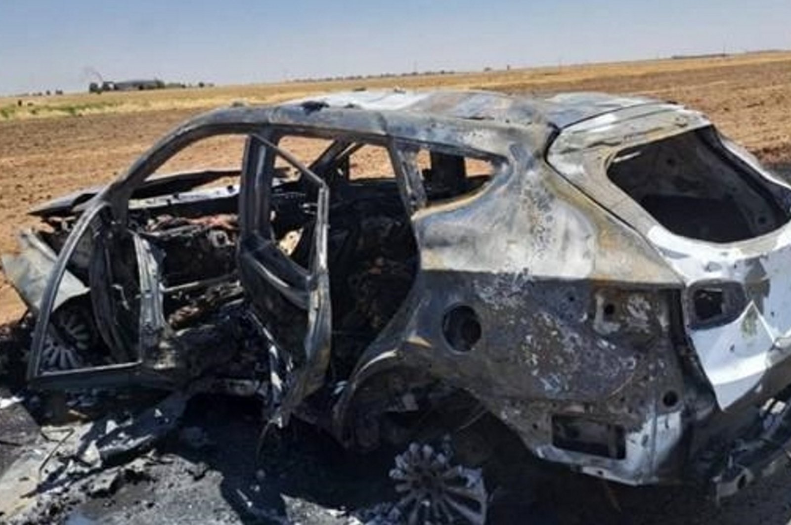 This undated photo taken in an undisclosed location shows the aftermath of a MIT strike targeting the car where "Bahoz Afrin" was traveling. (AA Photo)