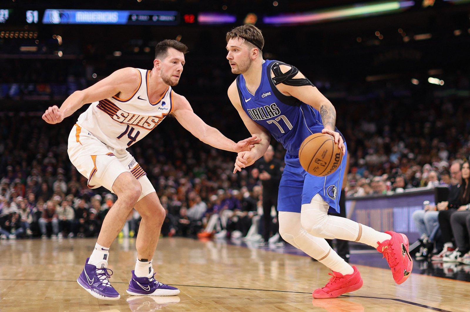Dallas Mavericks' Luka Doncic (R) handles the ball under pressure from Phoenix Suns' Drew Eubanks during the first half of the NBA game at Footprint Center, Phoenix, U.S., Dec. 25, 2023. (AFP Photo)