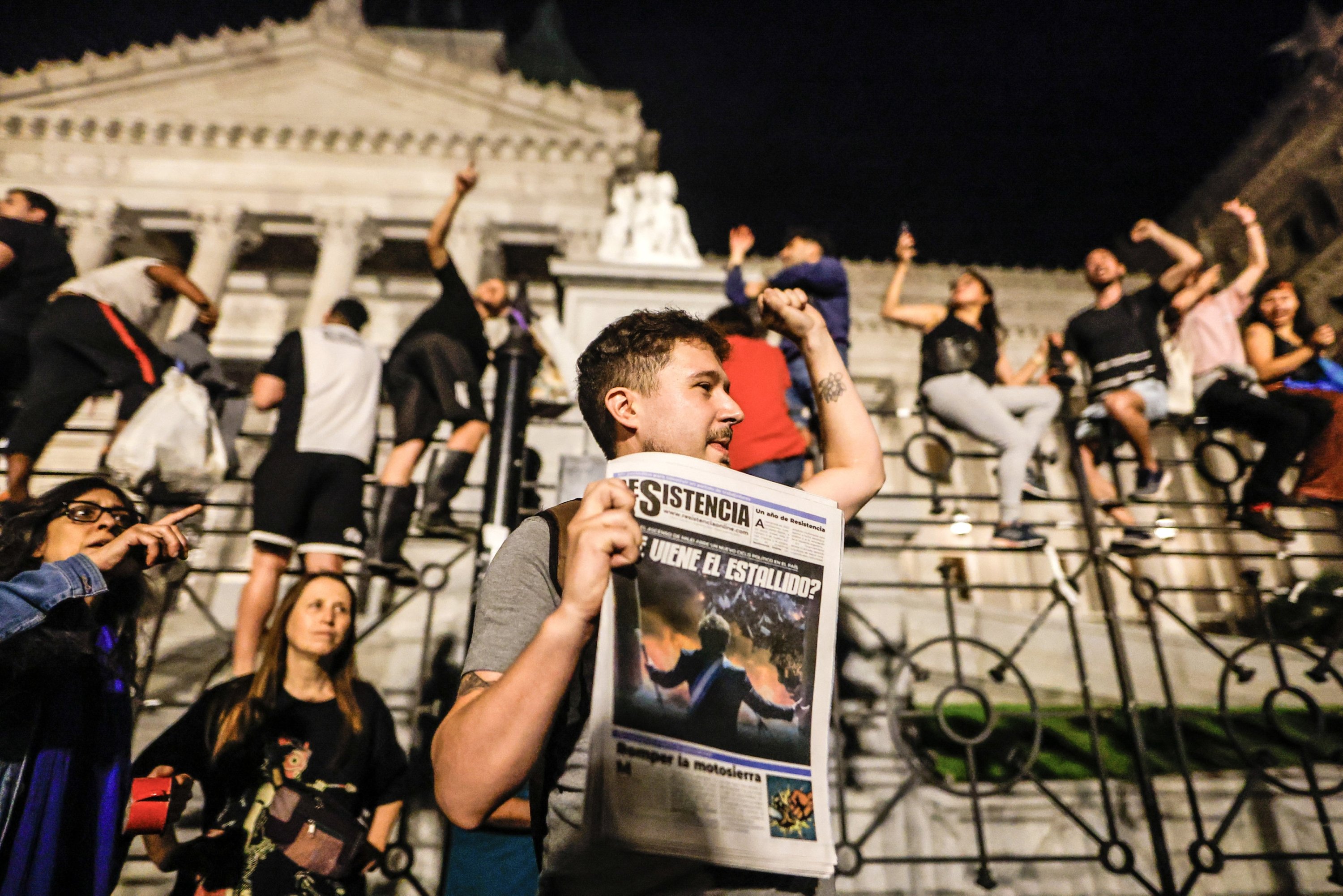 307587 A protester holds a newspaper as people take part in a demonstration against the measures announced by Argentina's President Javier Milei, in front of the National Congress in Buenos Aires, Argentina, Dec. 21, 2023. (EPA Photo)