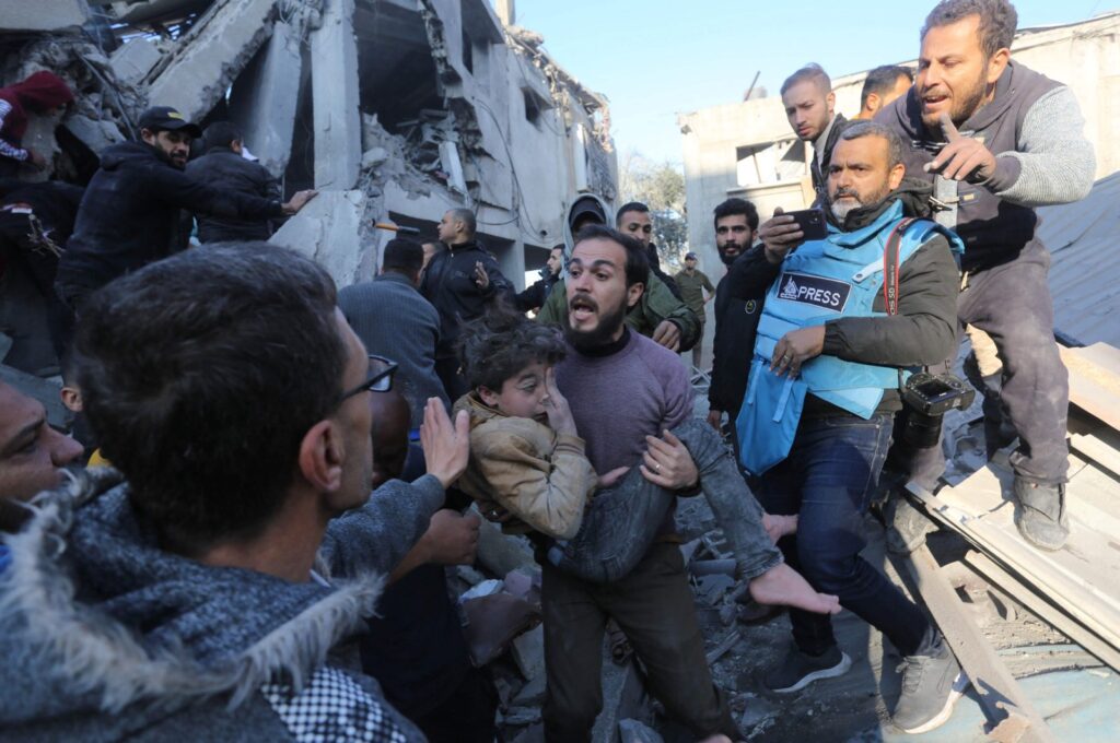 A Palestinian man evacuates a wounded girl from the site of an Israeli strike on the Zawayda area of the central Gaza Strip, Palestine, Dec. 30, 2023. (AFP Photo)