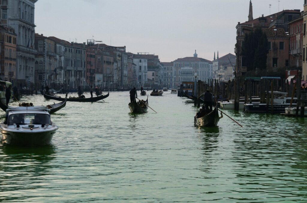 People ride in boats as waters of Grand Canal turned green after a protest by 'Extinction Rebellion' climate activists in Venice, Italy, Dec. 9, 2023. (Reuters Photo)