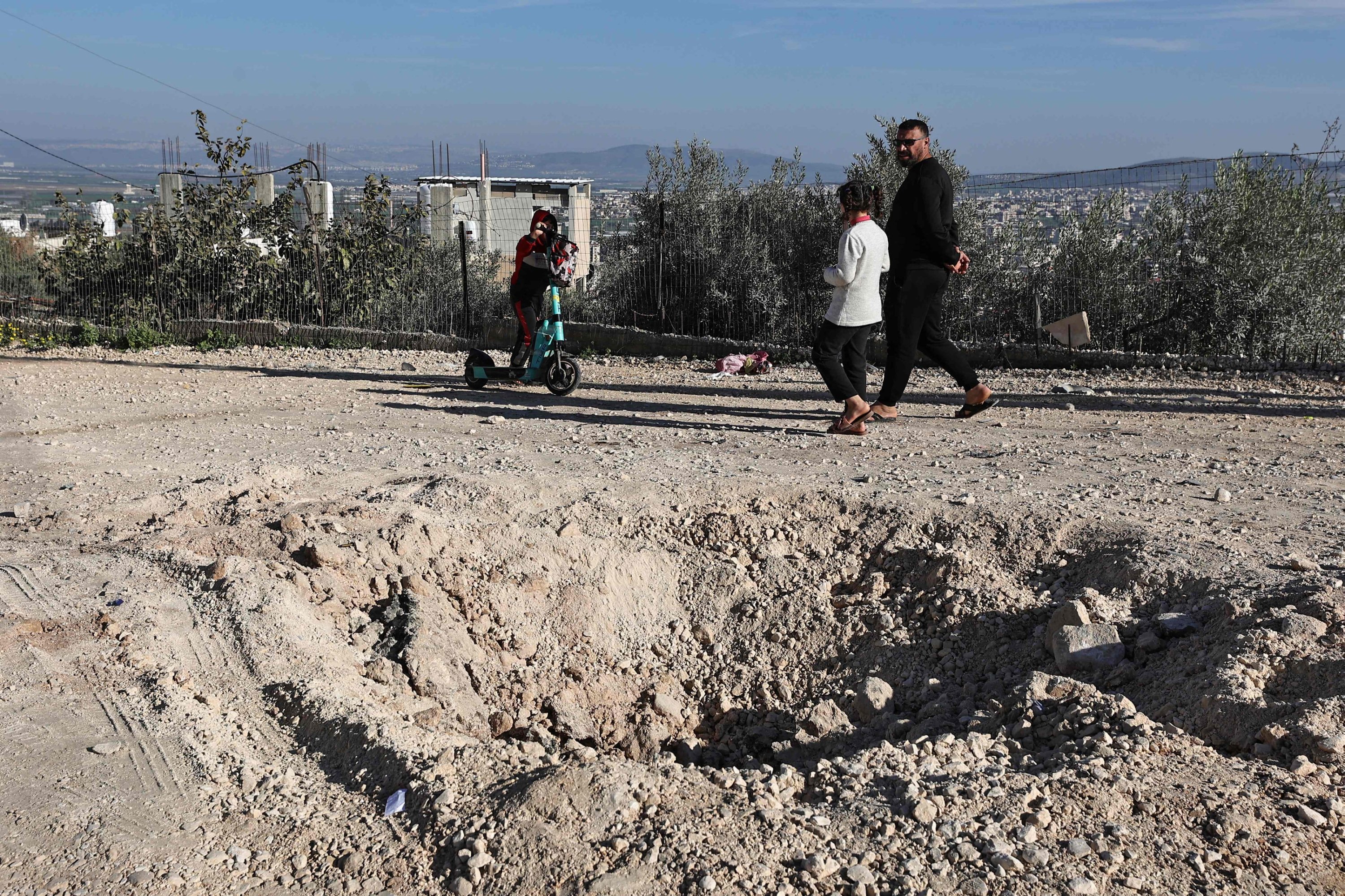 308923 People walk past a crater left by an explosive device that killed an Israeli officer during an Israeli raid in Jenin, in the occupied West Bank, Palestine, Jan. 7, 2024. (AFP Photo)