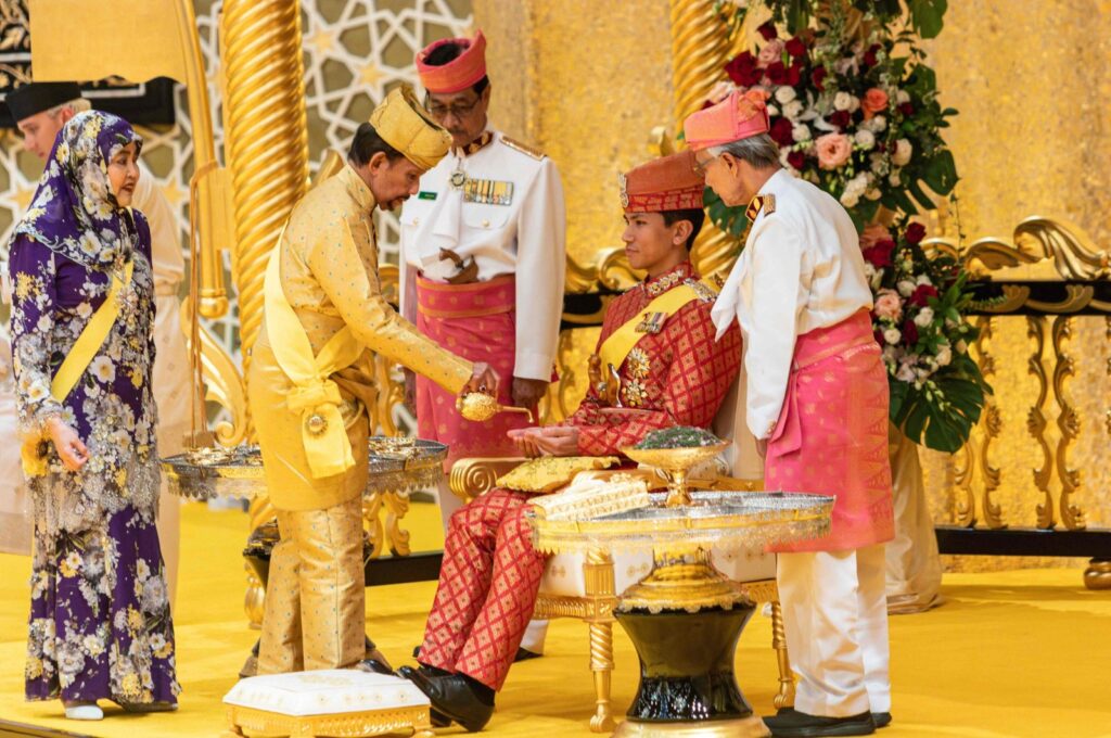 Brunei's Sultan Hassanal Bolkiah (2nd L) pouring scented oil on the hands of Prince Abdul Mateen during the royal powdering ceremony ahead of his wedding, Bandar Seri Begawan, Brunei, Jan. 10, 2024. (AFP Photo)