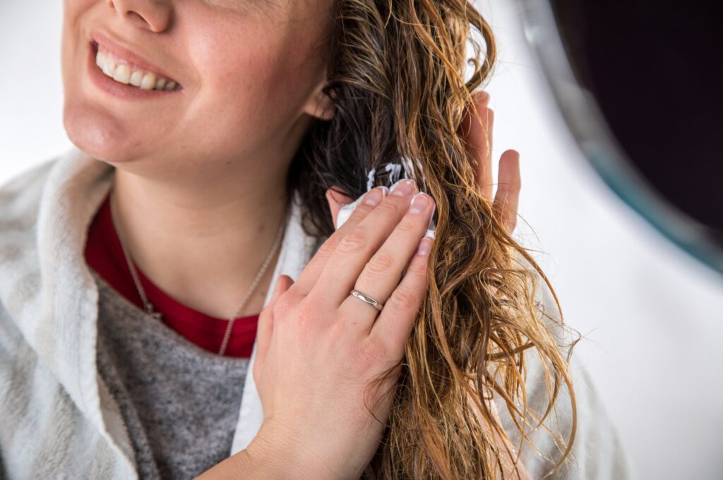 A Woman using a hair care product. (dpa Photo)