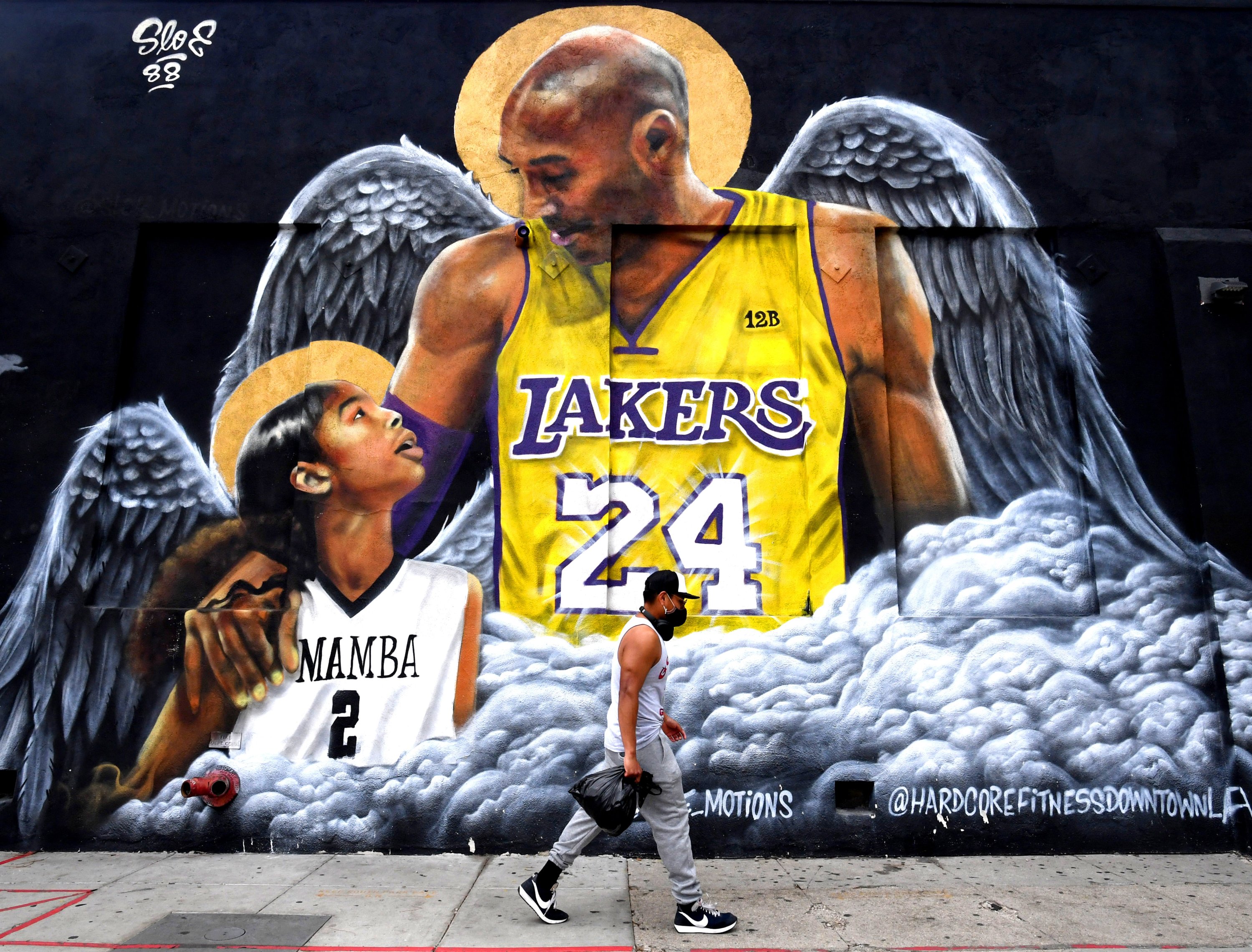 311829 A man walks past a Kobe Bryant and Gigi mural on the side of the Hardcore Fitness Bootcamp, Los Angeles, U.S., Jan. 22, 2021. (Getty Images Photo)