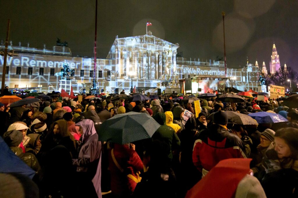 People take part in a rally under the motto "Defend Democracy" against right-wing extremism, racism and anti-Semitism as rain falls in front of the parliament in Vienna, Austria on Jan. 26, 2024. (AFP Photo)