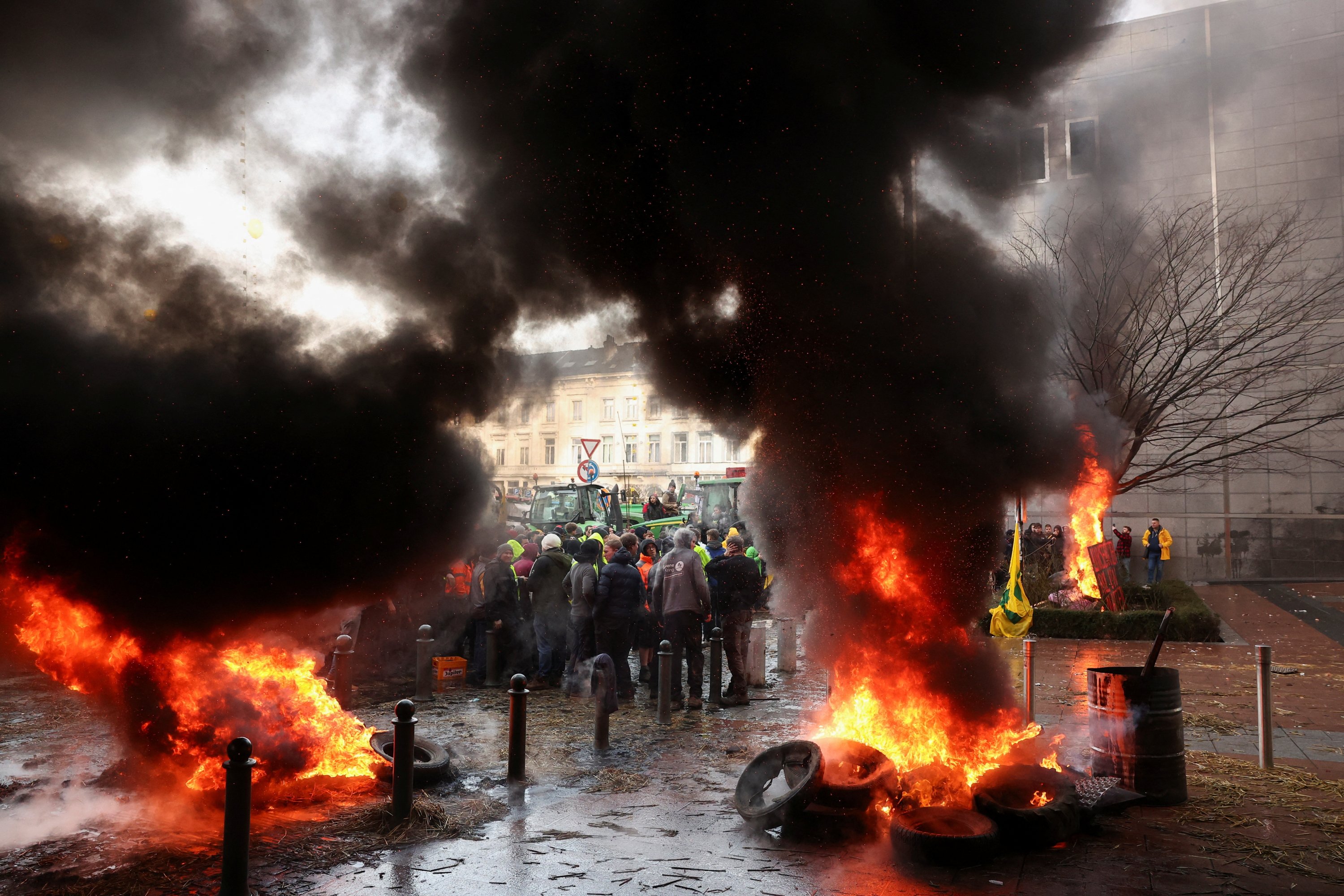 312854 Smoke rises from objects set on fire as people gather in front of the European Union headquarters as Belgian farmers use their tractors to block the headquarters to protest price pressures, taxes and green regulation, Brussels, Belgium, Feb. 1, 2024. (Reuters Photo)