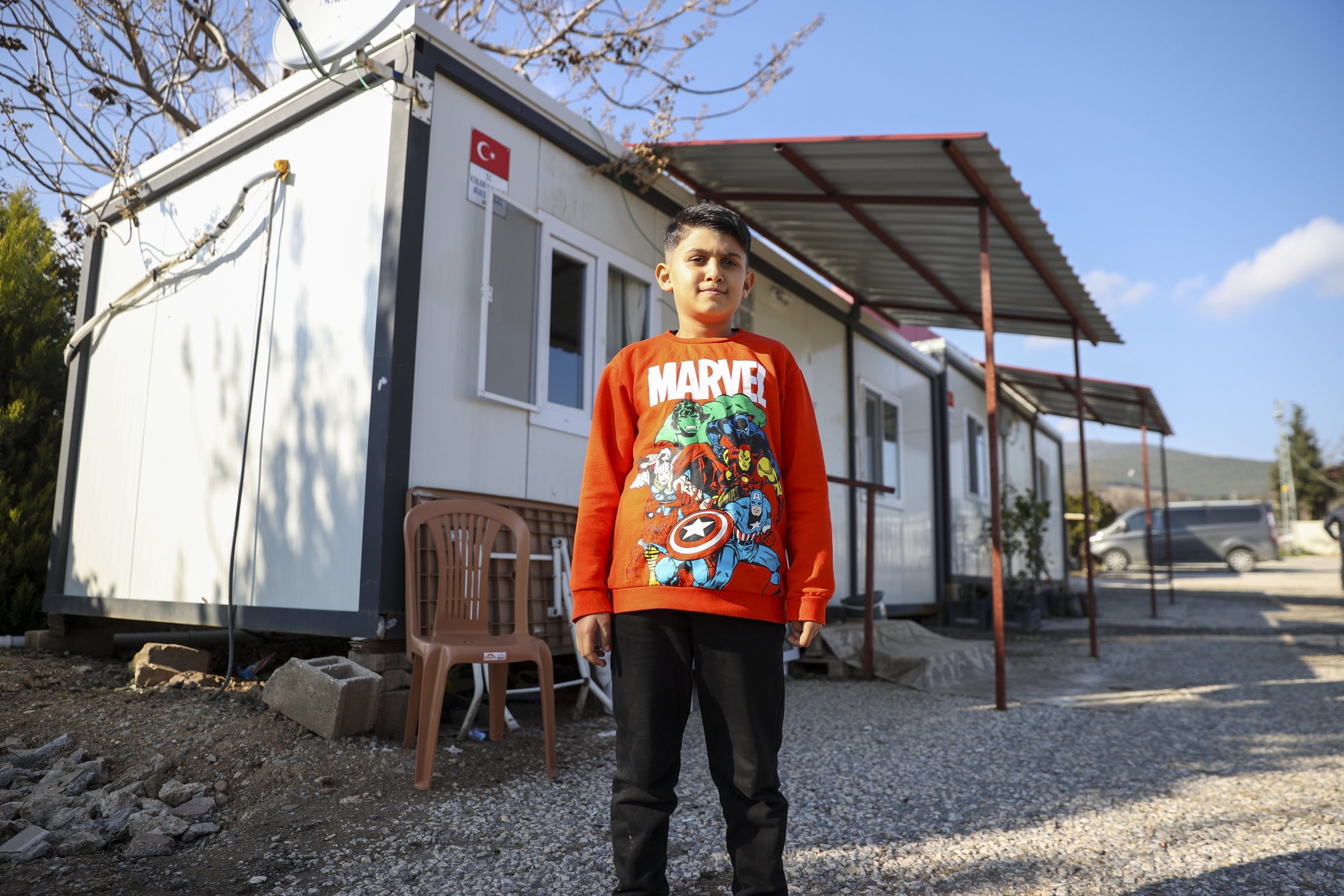 313415 Southeastern Türkiye earthquake survivor Semih Ege Inci stands in front of a container house, Gaziantep, Türkiye, Feb. 5, 2024. (AA Photo)
