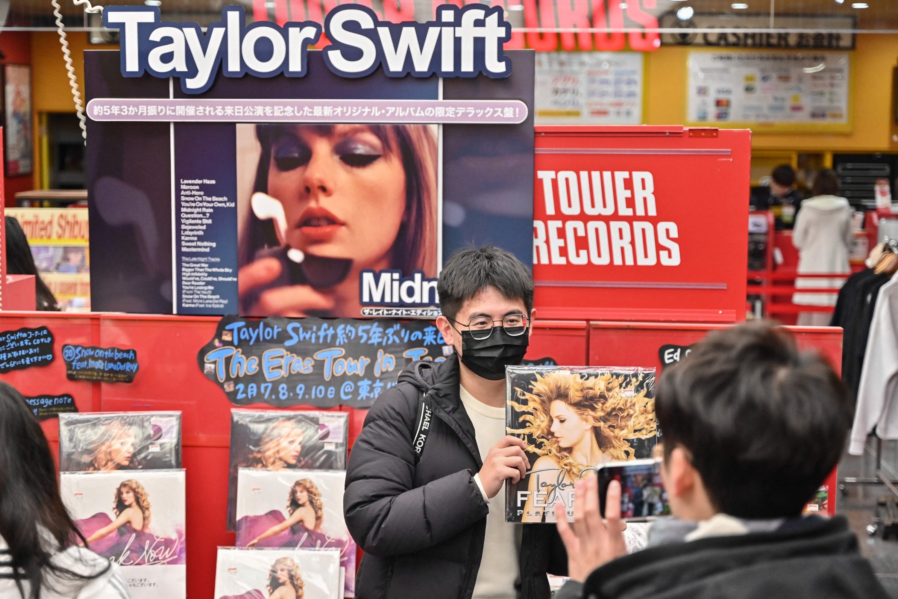 313734 A man (C) poses for a photo in front of a display of records by U.S. pop music sensation Taylor Swift, Tokyo, Japan, Feb. 7, 2024. (AFP Photo)