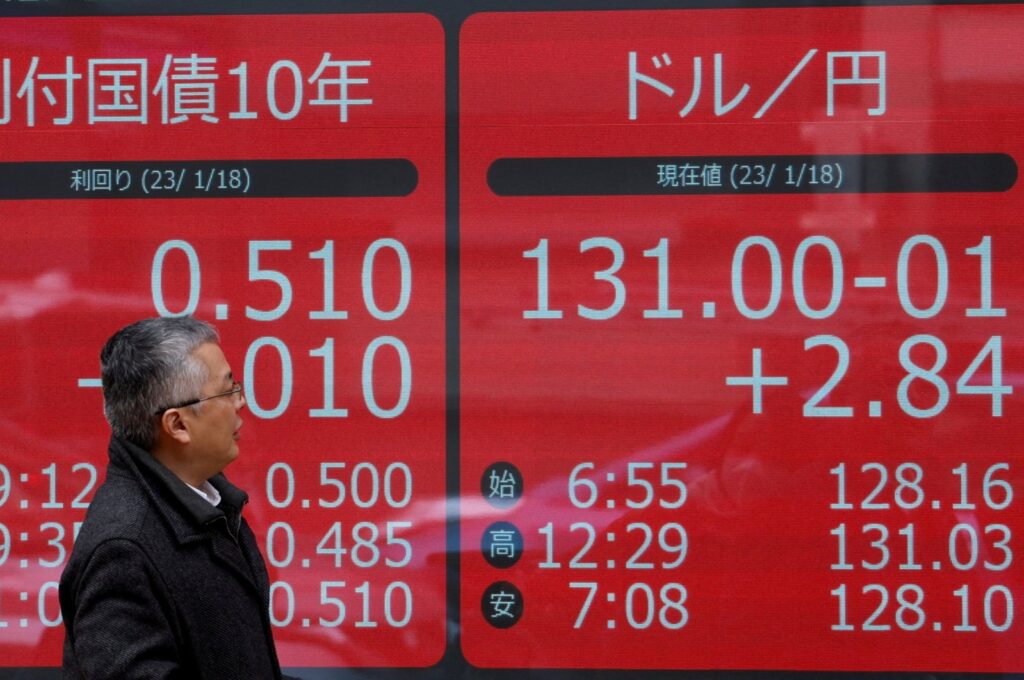 A man looks at electric monitors displaying Japan's 10-year government bond yield on gilts and the exchange rate between the Japanese yen against the U.S. dollar outside a brokerage in Tokyo, Japan, Jan. 18, 2023. (Reuters Photo)