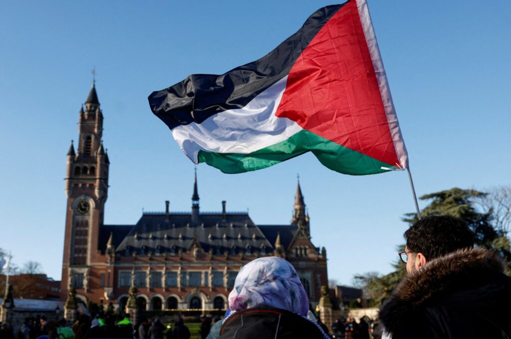 Protesters hold a Palestinian flag as they gather outside the International Court of Justice (ICJ) as judges rule on emergency measures against Israel following accusations by South Africa that the Israeli military operation in Gaza is a state-led genocide, in The Hague, Netherlands, Jan. 26, 2024. (Reuters File Photo)