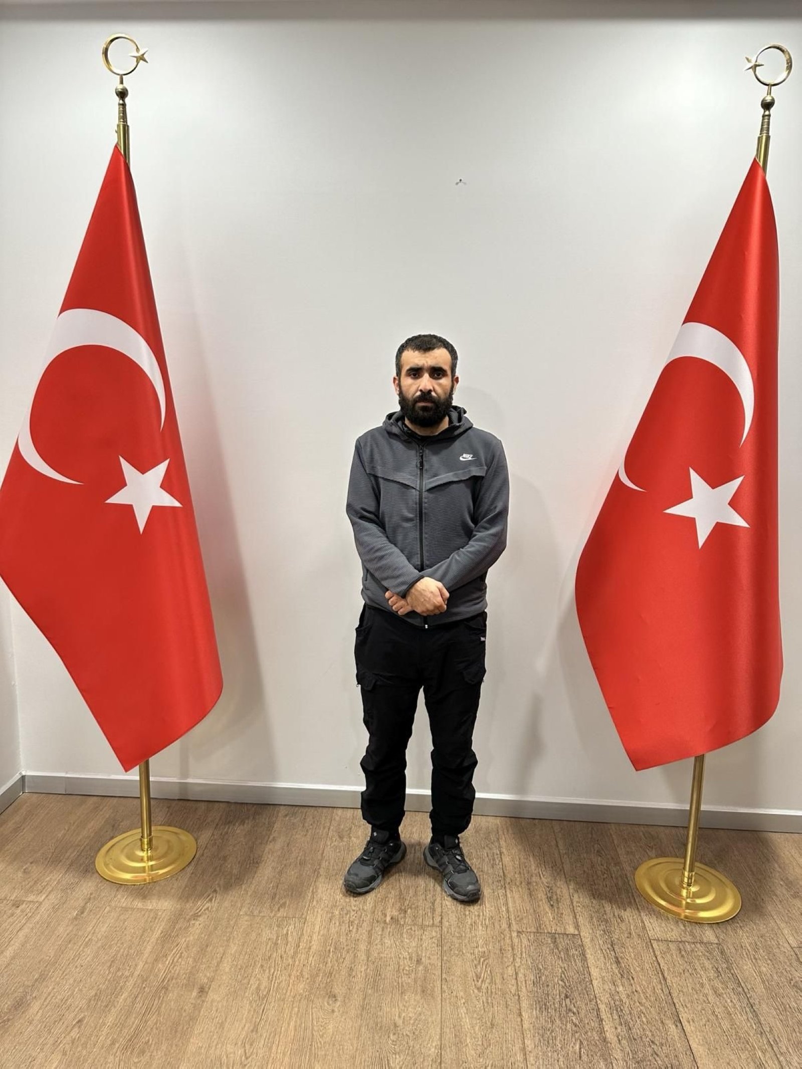 316481 A photo of Murat Kızıl between Turkish flags after his capture, taken in an undisclosed location. (DHA Photo)