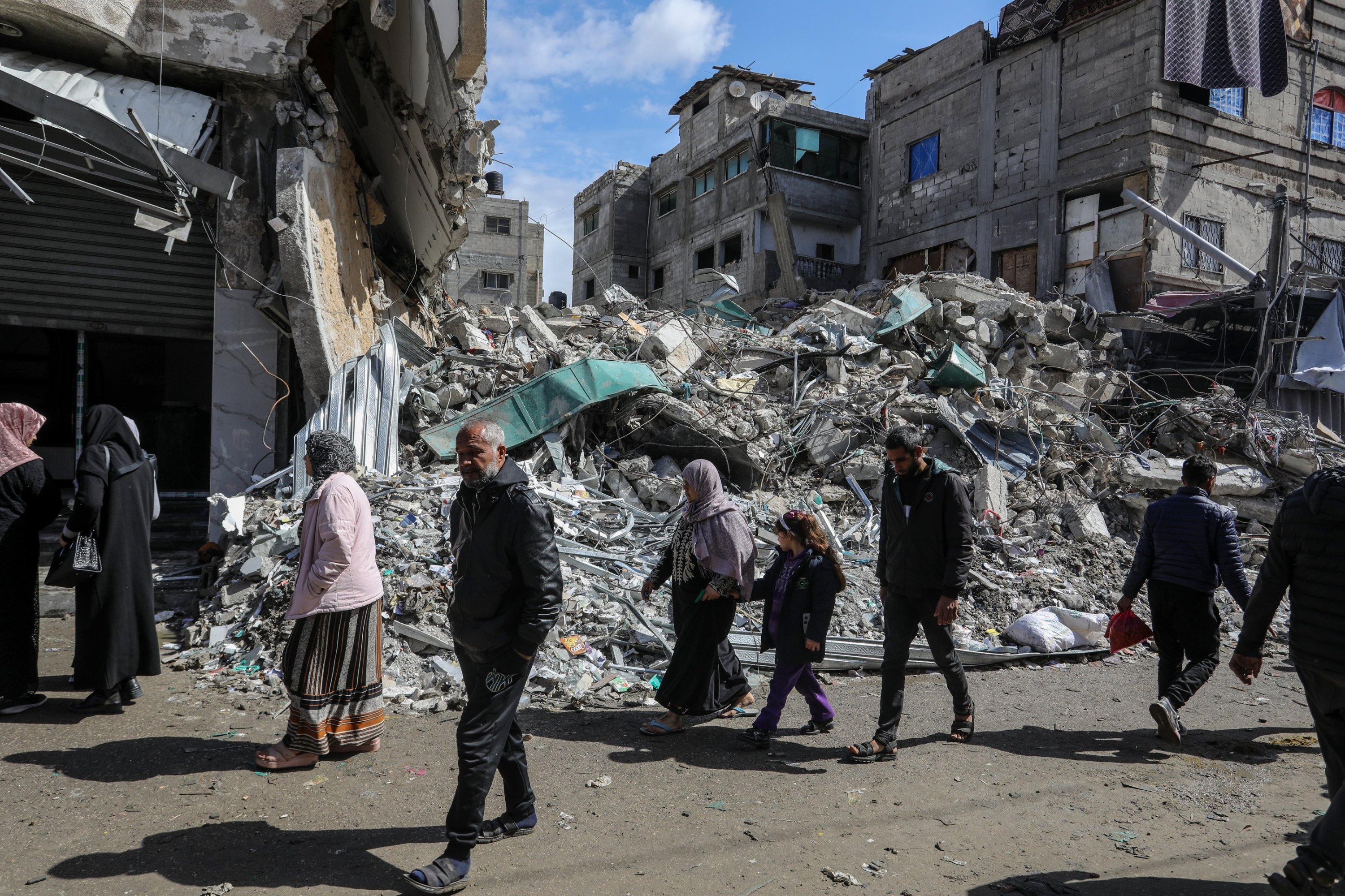 318553 Displaced Palestinians walk in front of a house destroyed in Israeli attacks, Rafah, Gaza Strip, Palestine, March 7, 2024. (AA Photo)