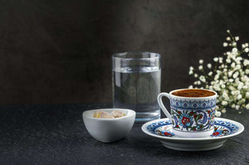A traditional cup of Turkish coffee with foam, water glass and Turkish delights. (Shutterstock Photo)