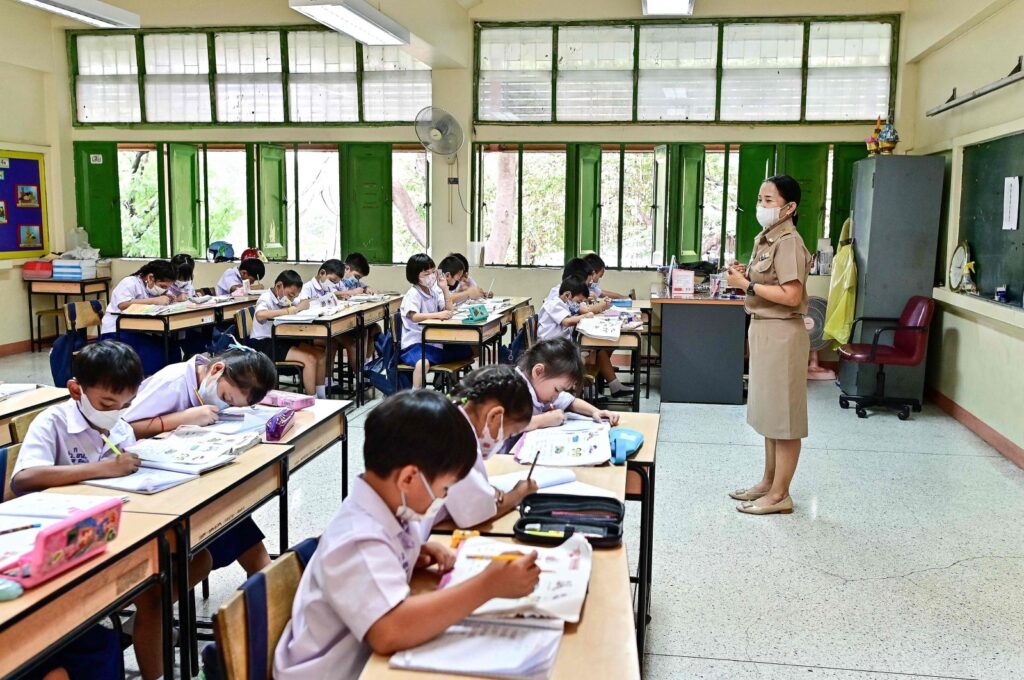 Students at Suanlumpinee School in Bangkok wear face masks while singing the national anthem amid traffic pollution outside their open classroom windows, Bangkok, Thailand, Jan. 22, 2024. (AFP Photo)
