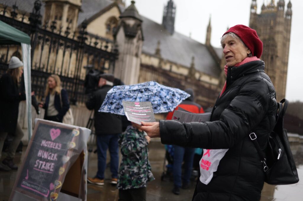 A food poverty campaigner with Mother's Manifesto hands out fliers as they demonstrate outside Parliament on Mother's Day, London, Britain, March 10, 2024. (EPA Photo)