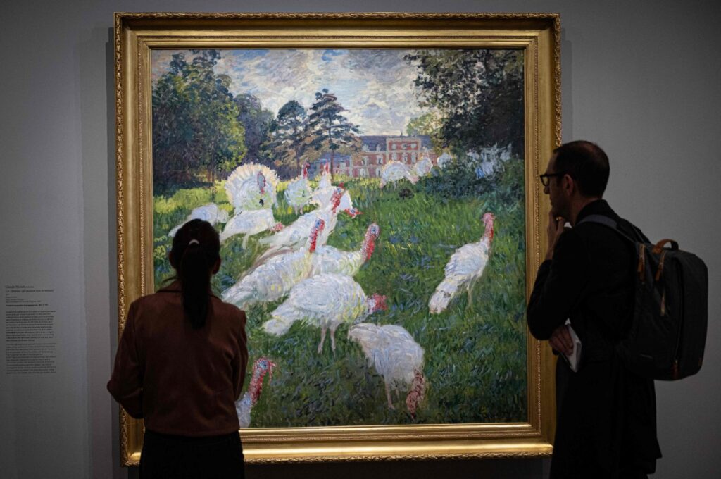 Visitors stand in front of the painting "Les Dindons" (The Turkeys - 1876) by French impressionist painter Claude Monet (1840-1926), Paris, France, March 22, 2024. (AFP Photo)
