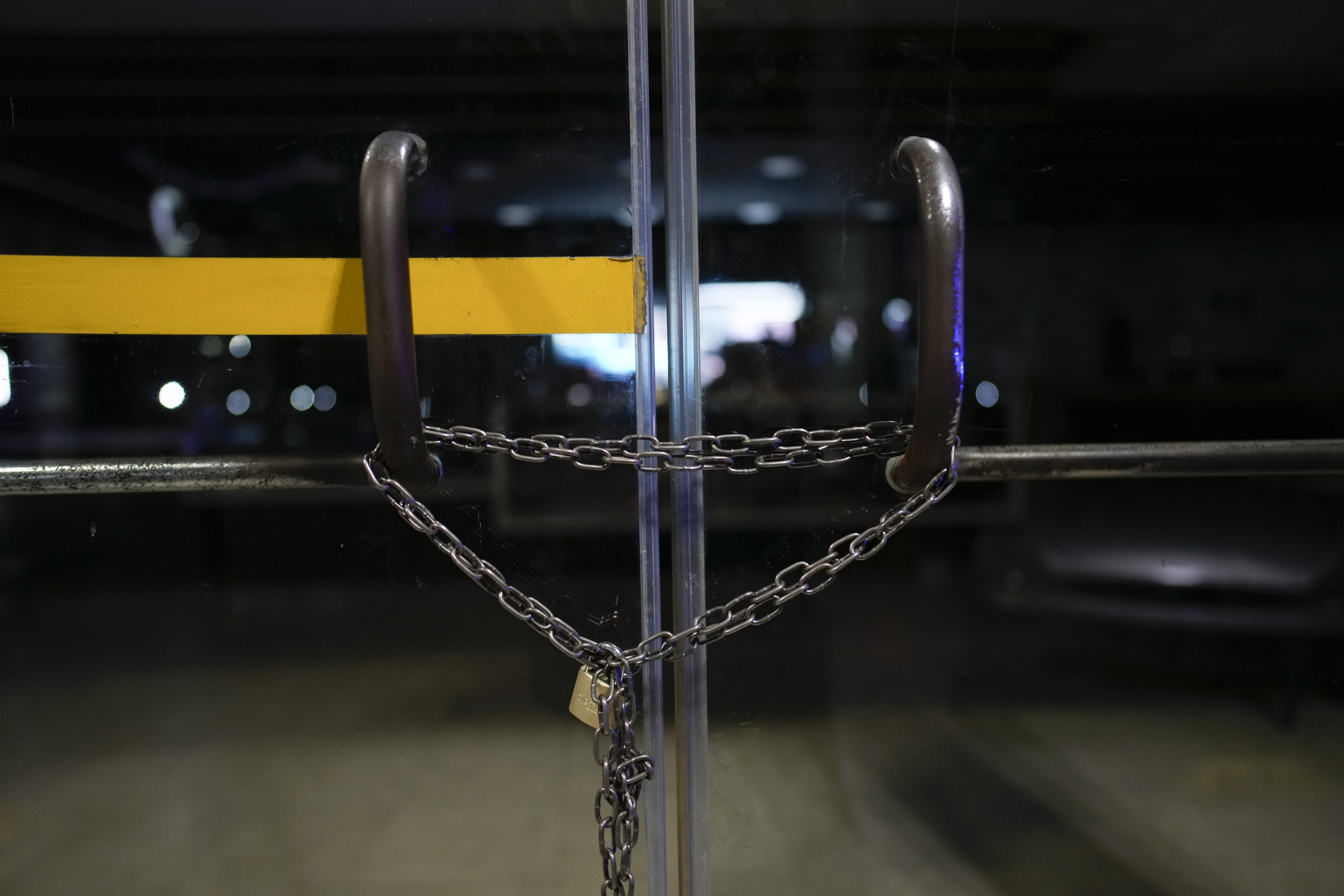 324489 A chain lock reinforces the locked door of a gas station that started closing shop at night after the killing of a worker at a nearby station a few weeks before, Rosario, Argentina, April 8, 2024. (AP Photo)
