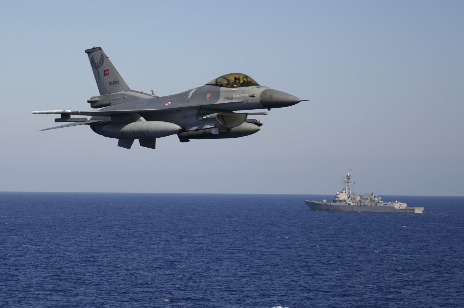 A Turkish F-16 fighting jet flies over naval ships during an annual NATO naval exercise on Türkiye's western coast on the Mediterranean, Sept. 15, 2022.  (AP Photo)