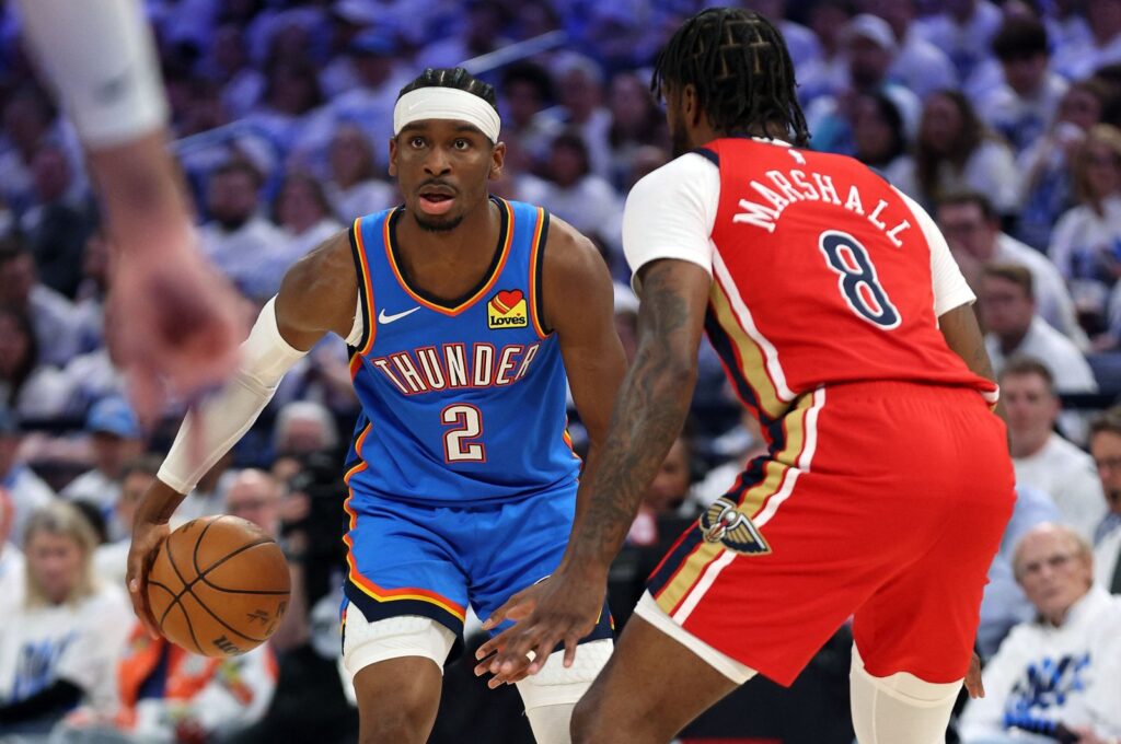 Oklahoma City Thunder's Shai Gilgeous-Alexander (L) controls the ball as New Orleans Pelicans' Naji Marshall defends during game two of the first round of the NBA playoffs at Paycom Center, Oklahoma, U.S., April 24, 2024. (AFP Photo)