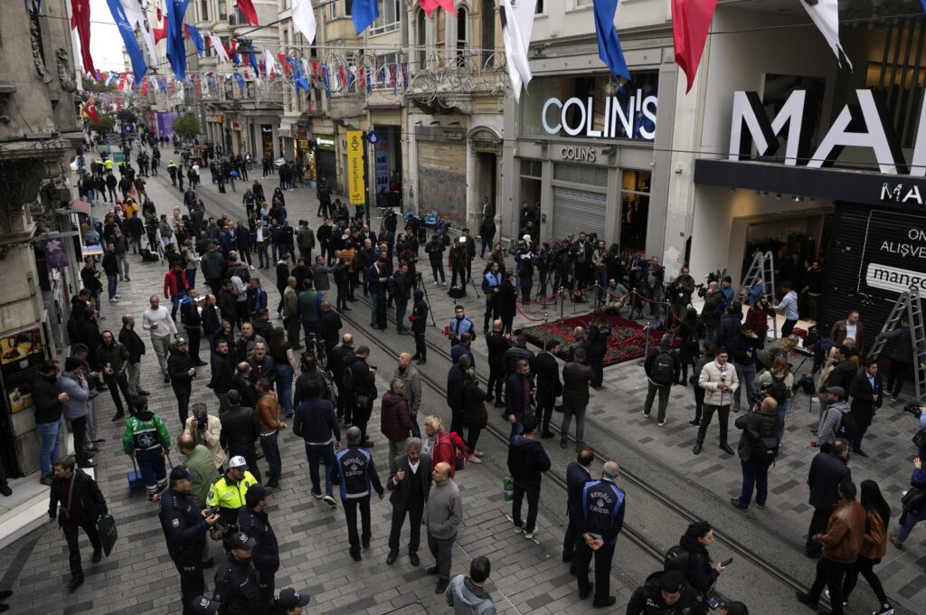 People gather around a memorial placed on the spot of the attack, Istanbul, Türkiye, Nov. 14, 2022. (AP Photo)