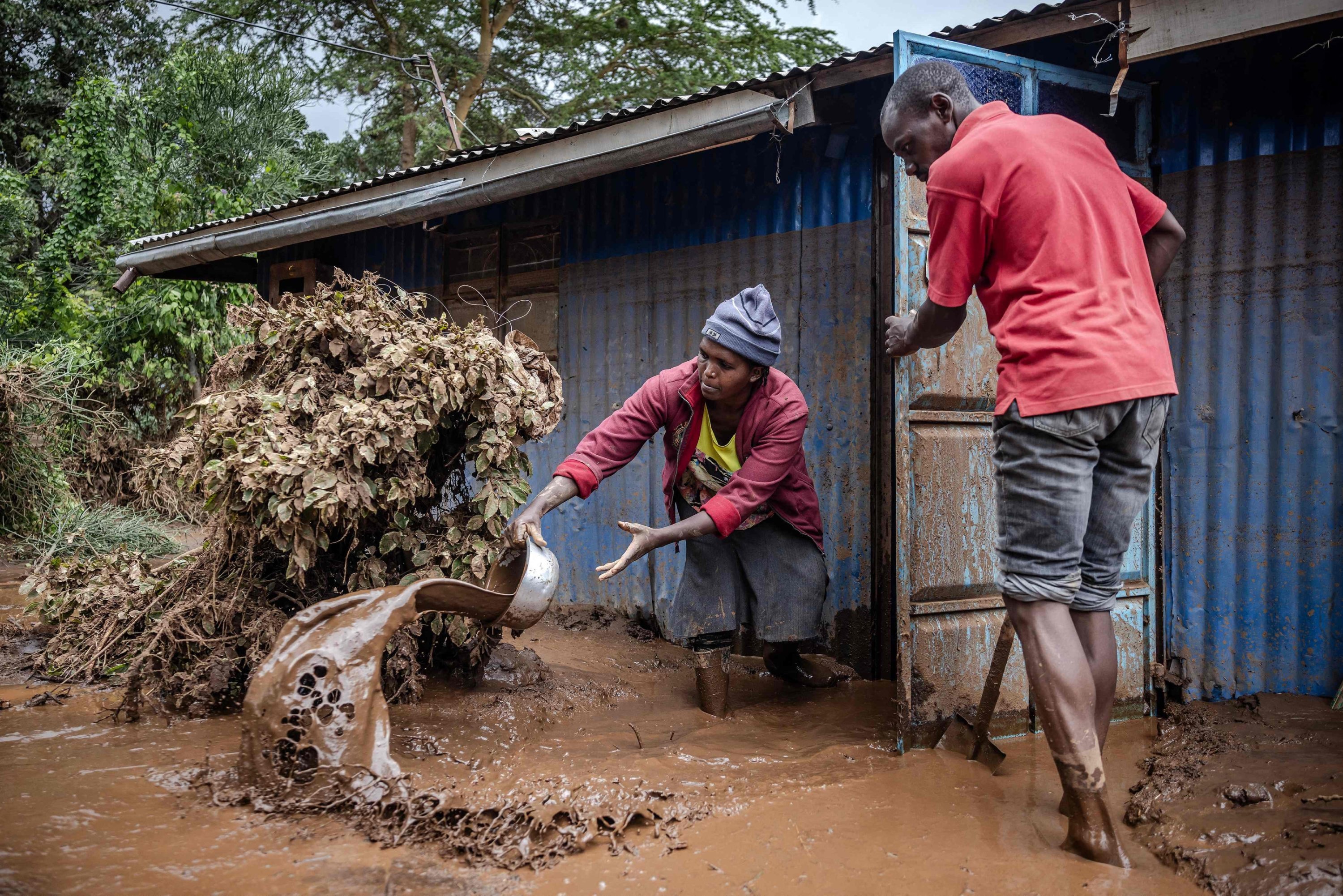 325720 A woman and a man take mud and water out of their house in an area heavily affected by torrential rains and flash floods in Mai Mahiu, Kenya, April 29, 2024. (AFP Photo)